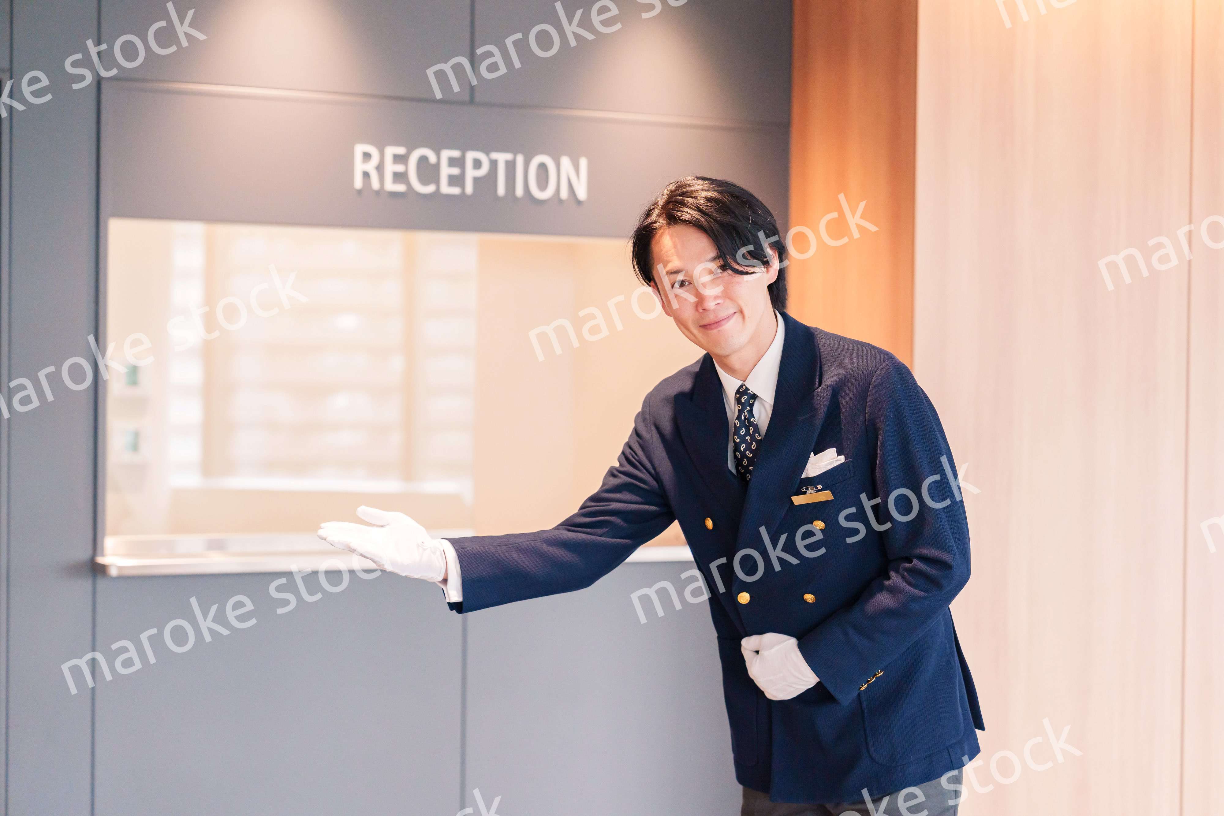 笑顔で接客をするホテルマンの男性