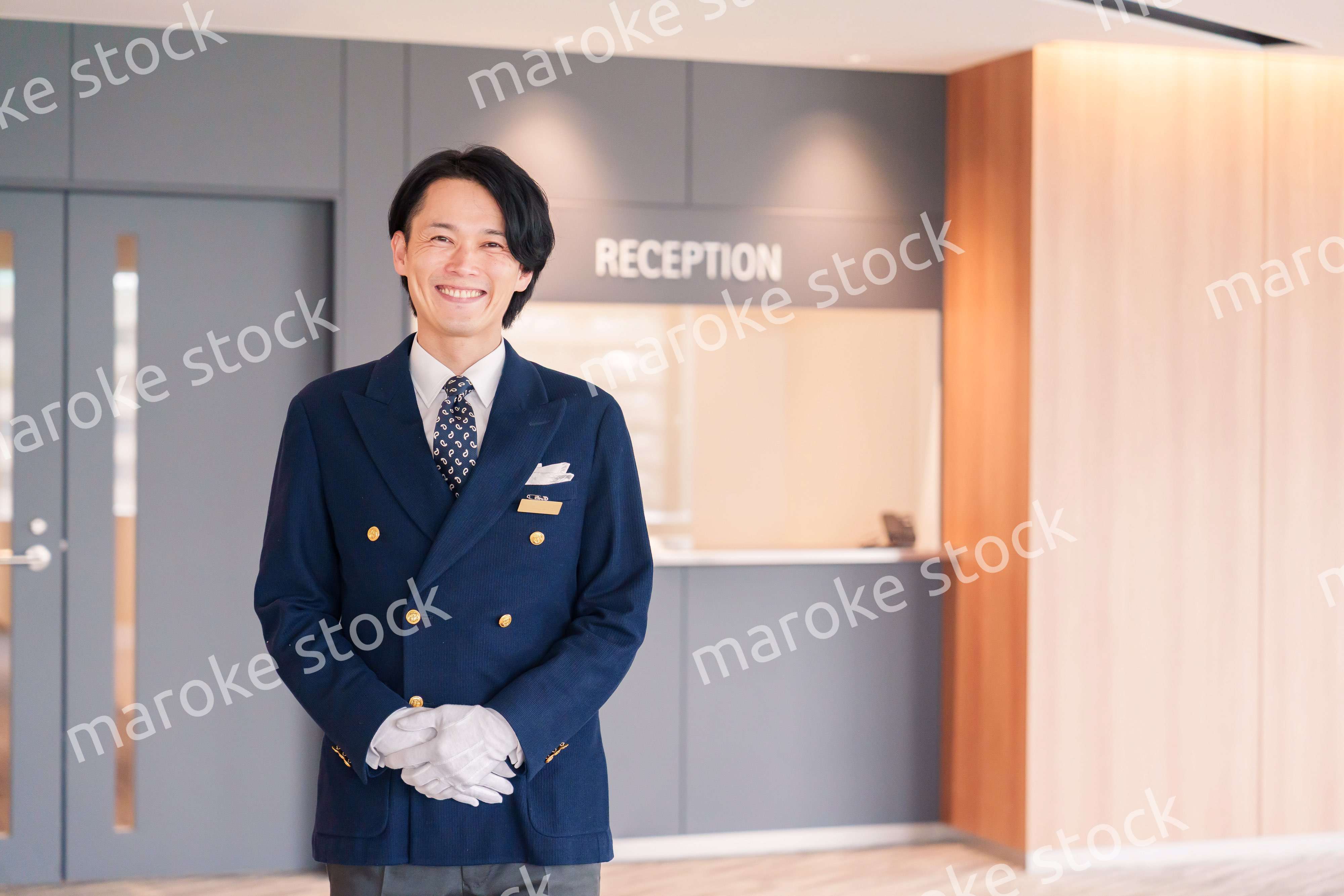 笑顔で接客をするホテルマンの男性