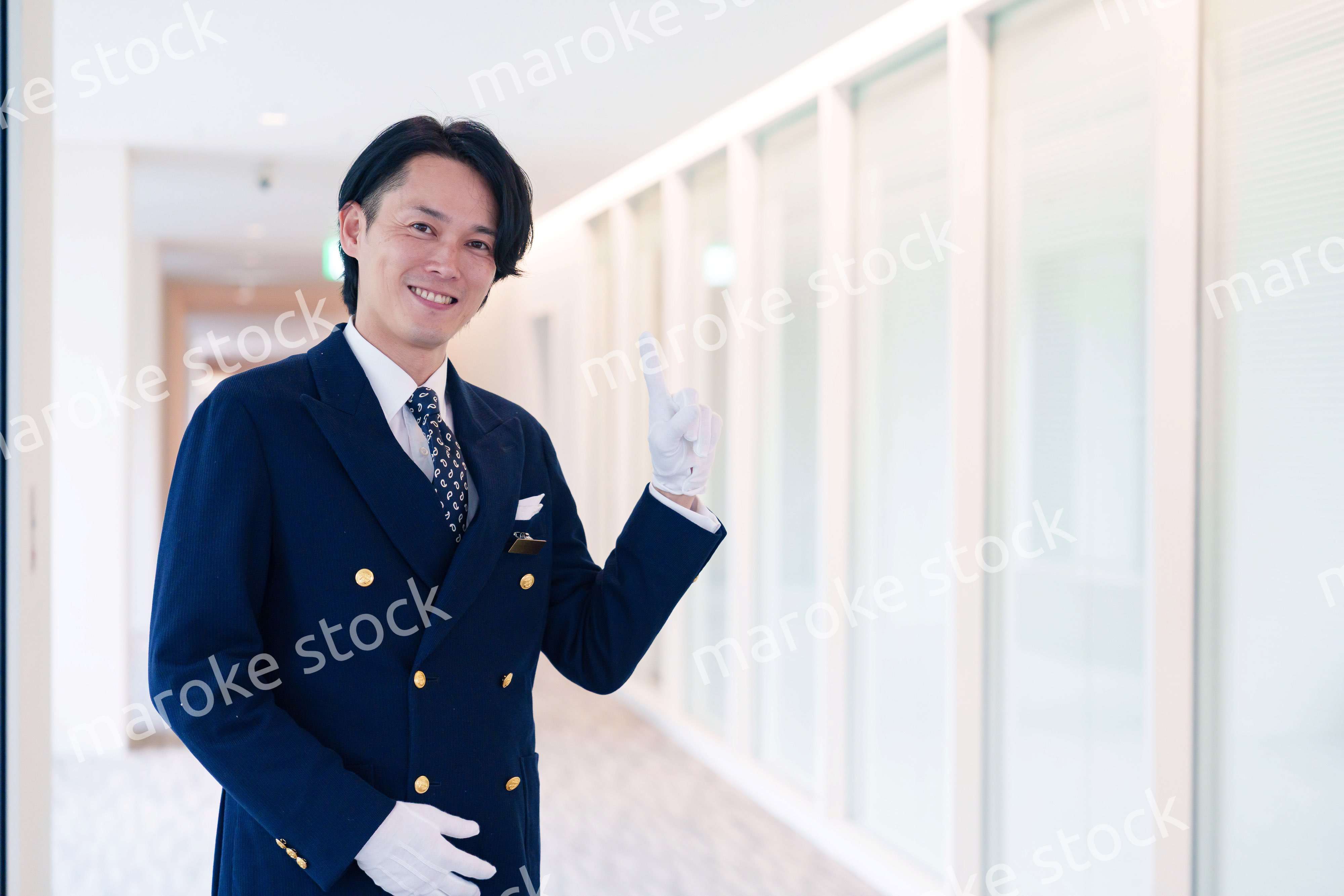 笑顔で接客をするホテルマンの男性
