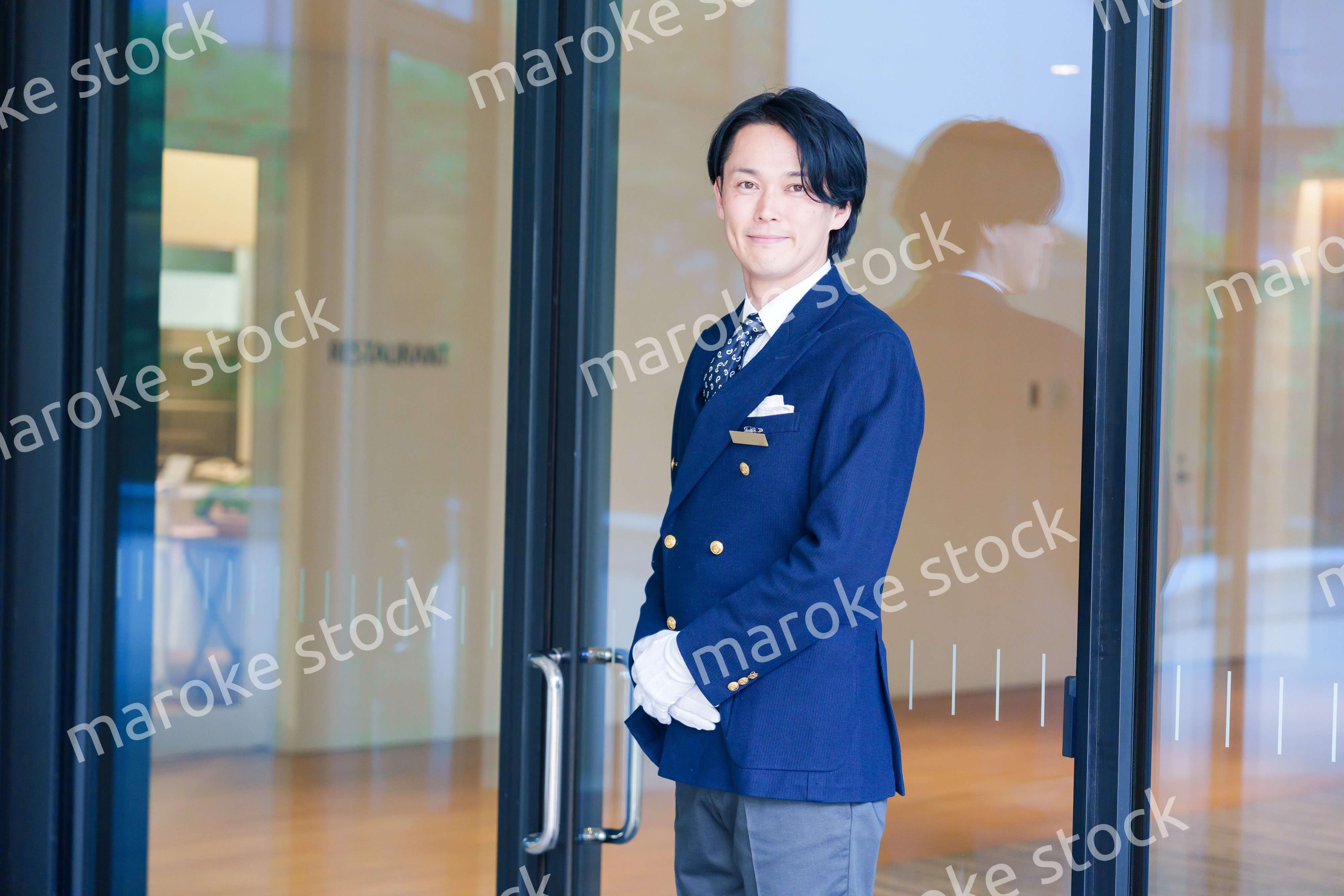 笑顔で接客をするホテルマンの男性