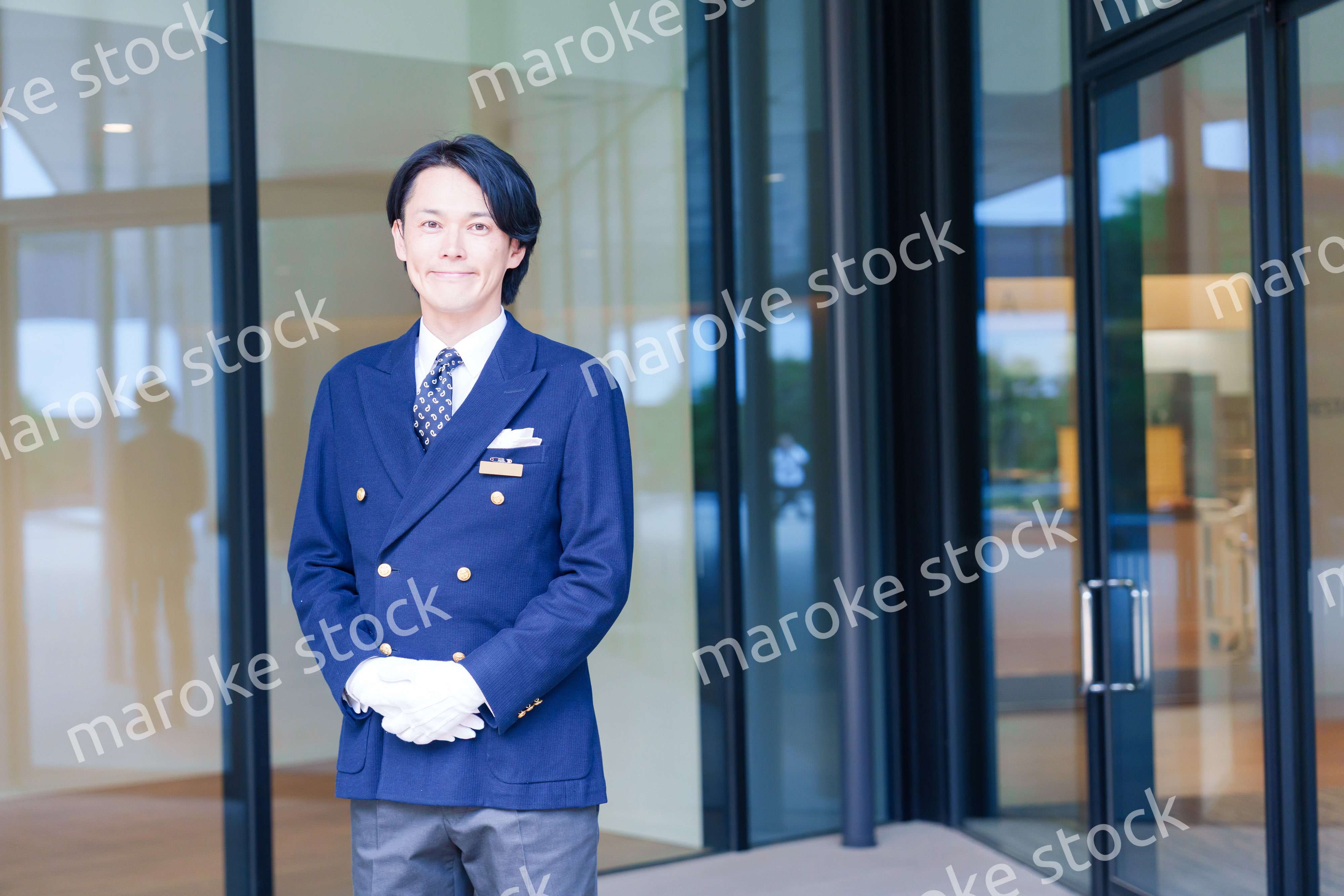 笑顔で接客をするホテルマンの男性