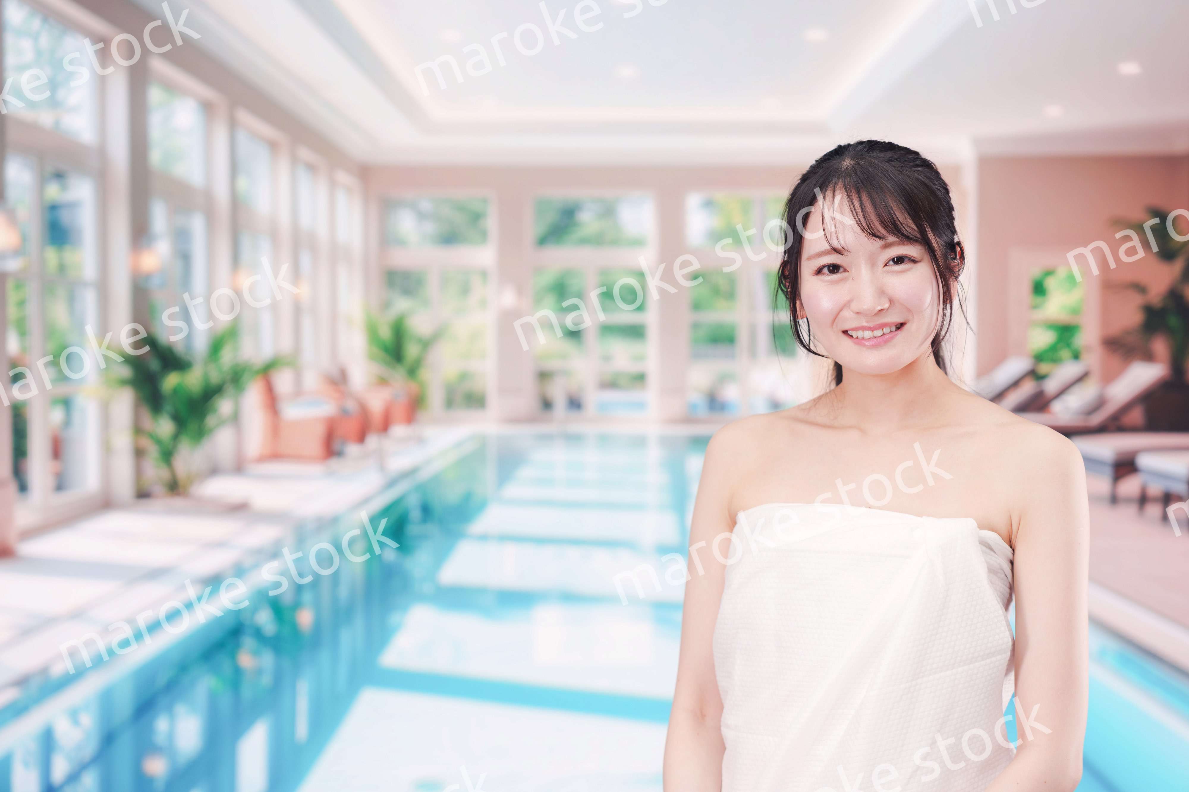 屋内プールを楽しむ若い女性