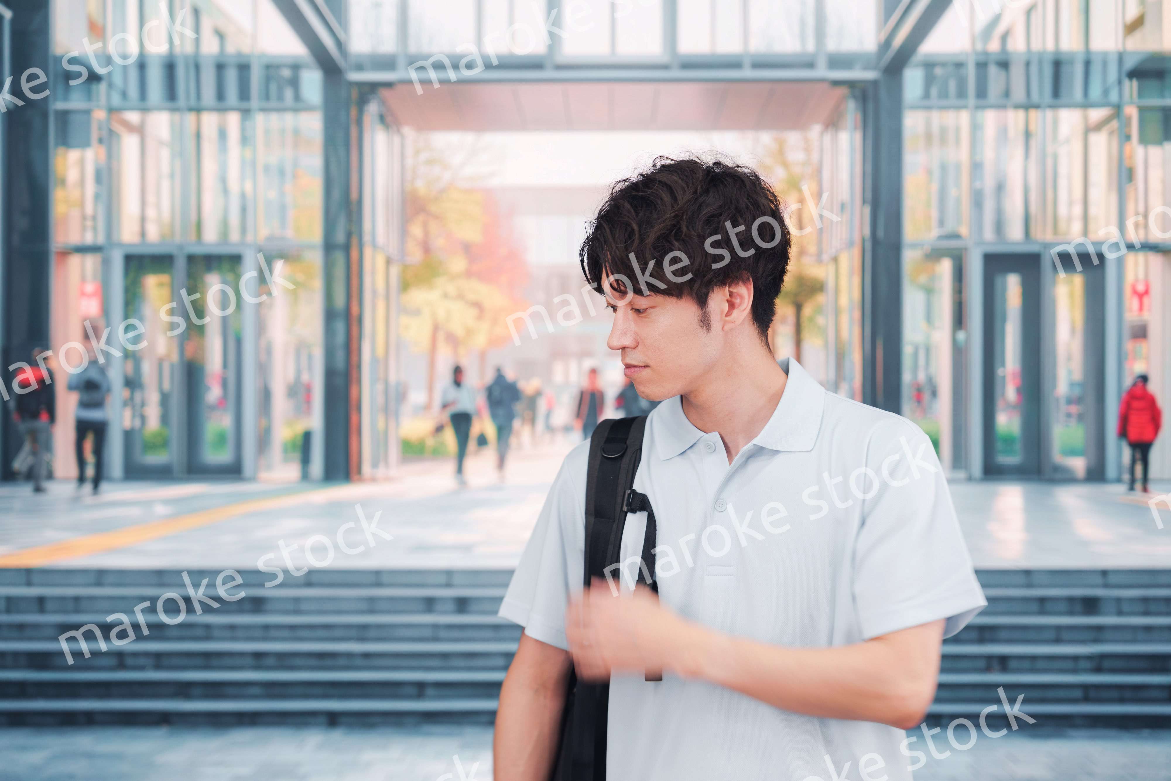 大学のキャンパス内を歩く男子学生