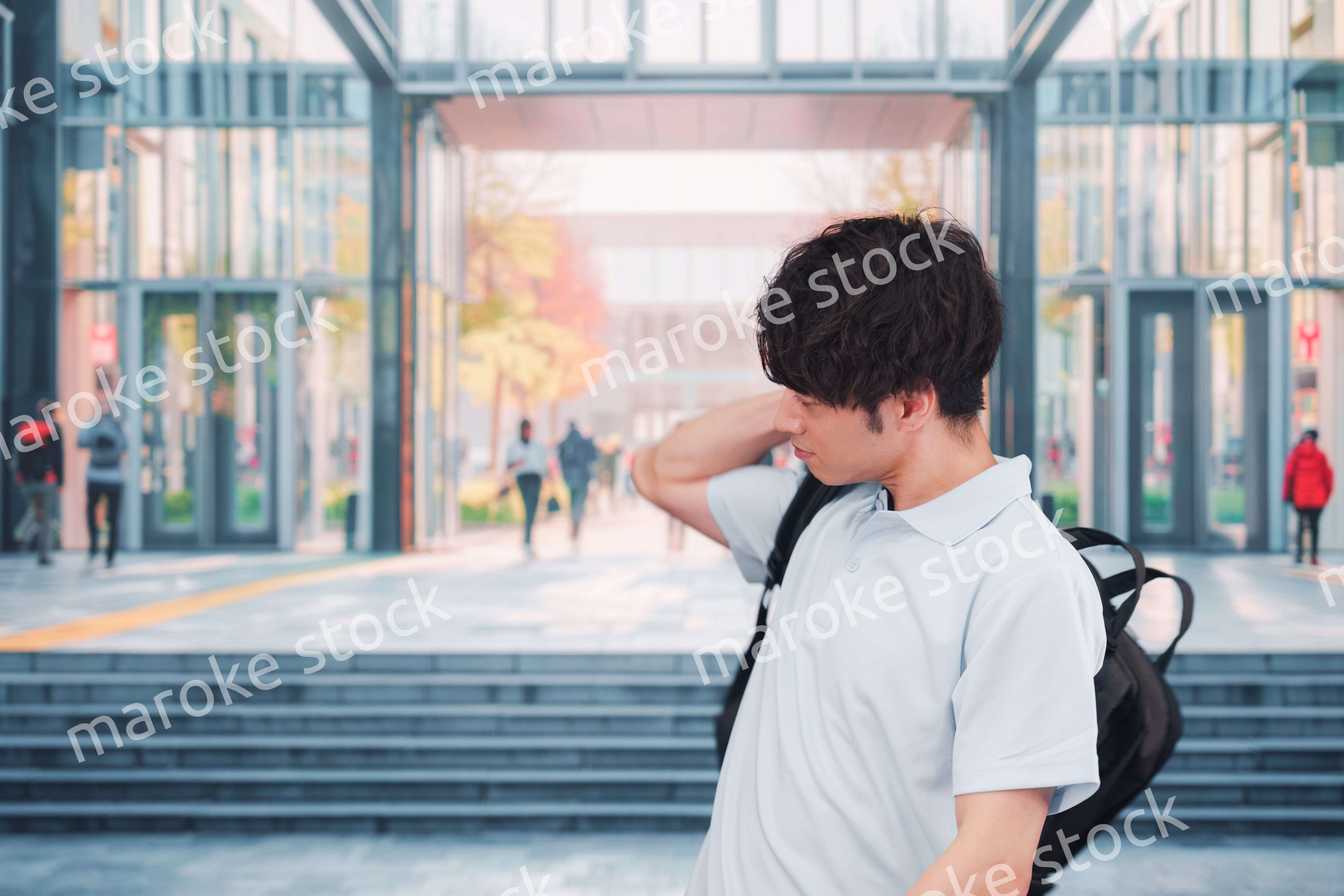 大学のキャンパス内を歩く男子学生