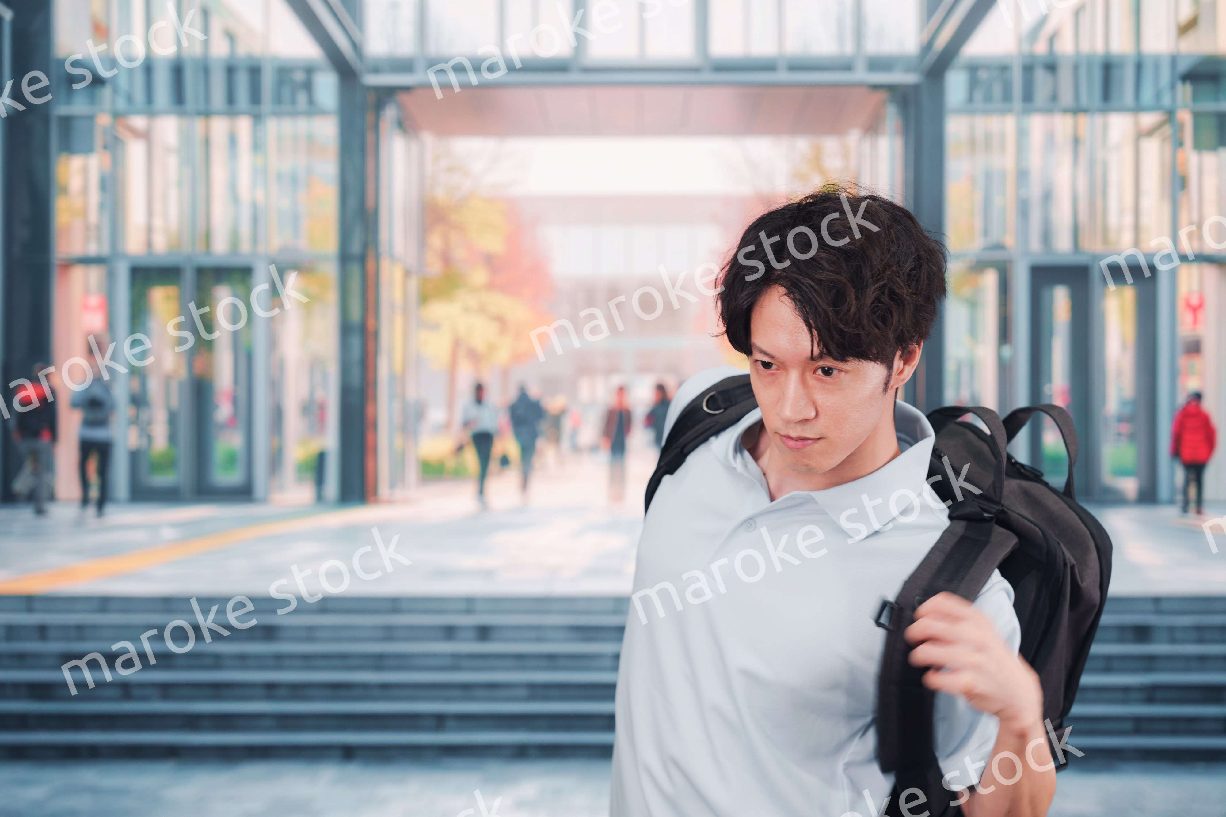 大学のキャンパス内を歩く男子学生