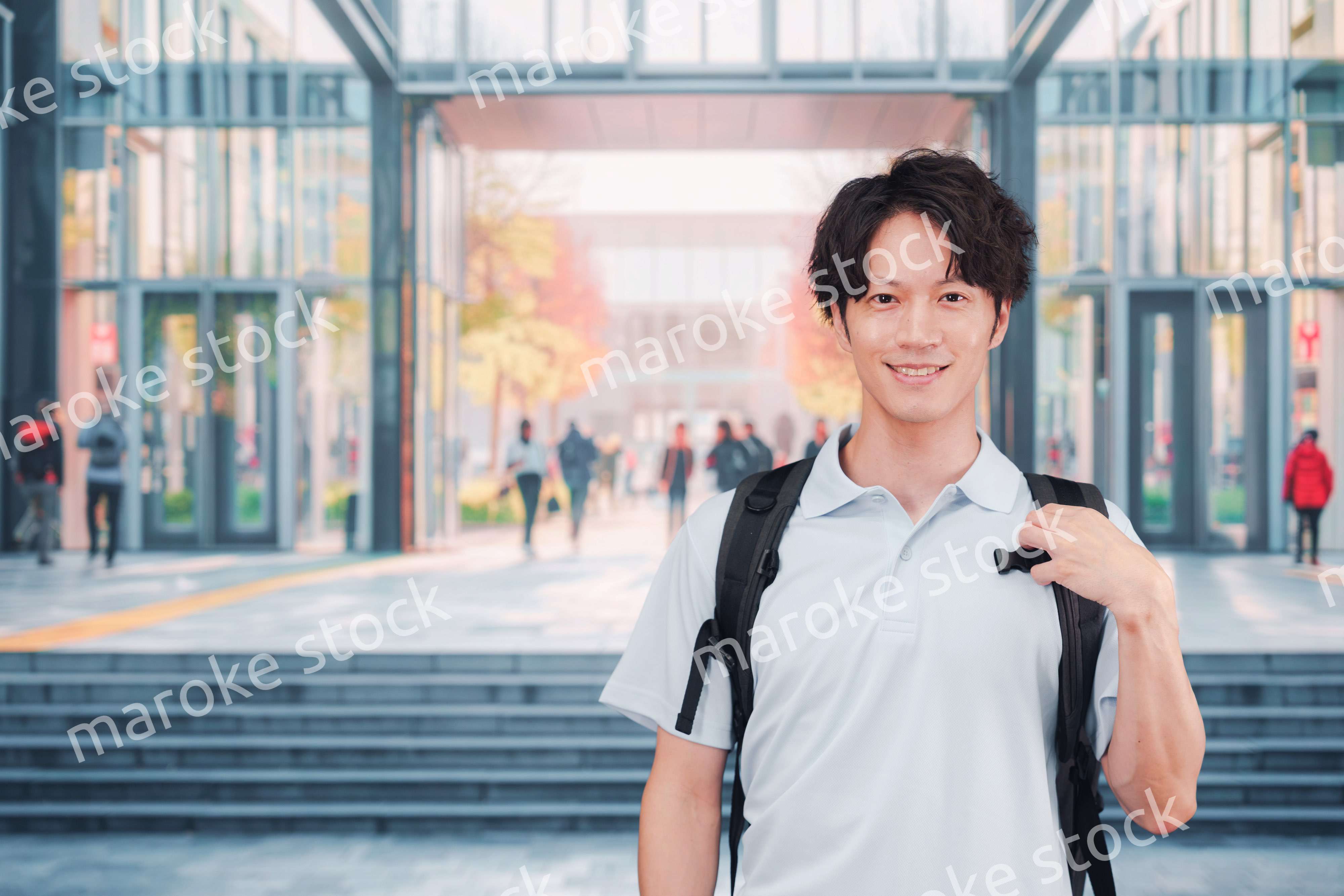 大学のキャンパス内を歩く男子学生