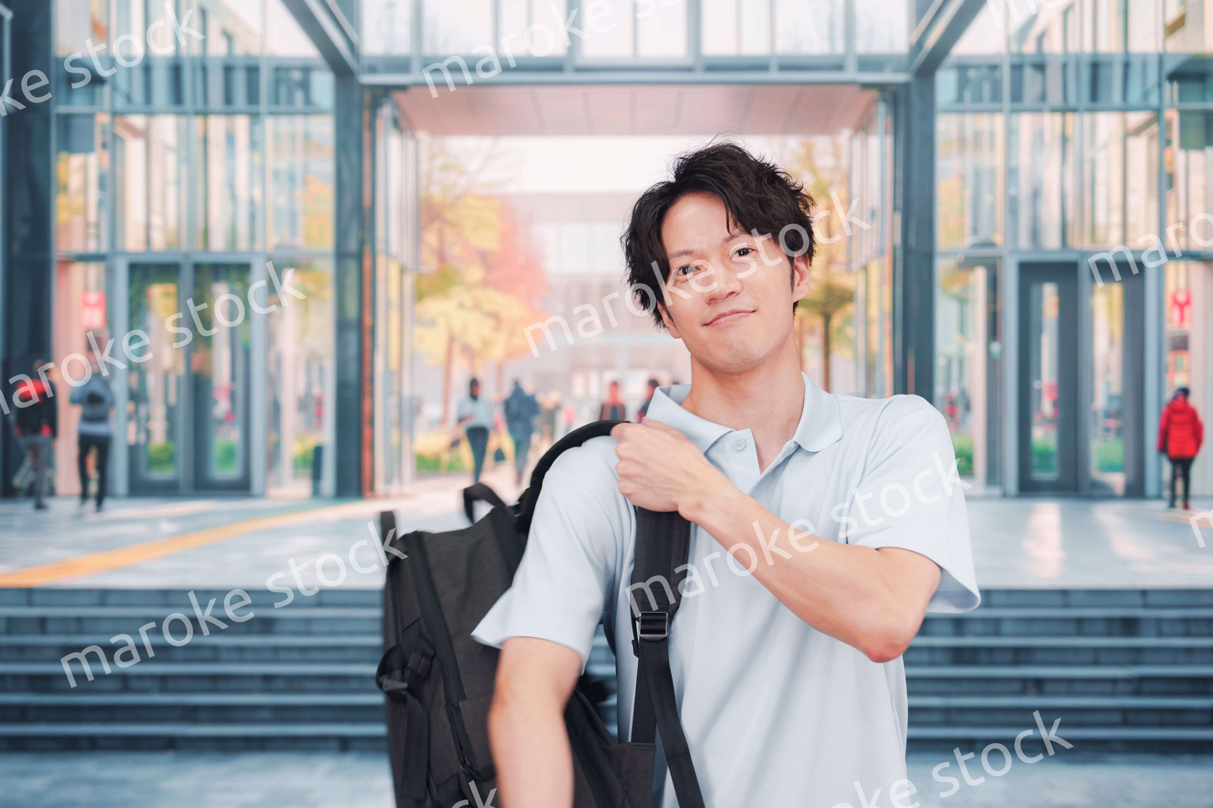 大学のキャンパス内を歩く男子学生