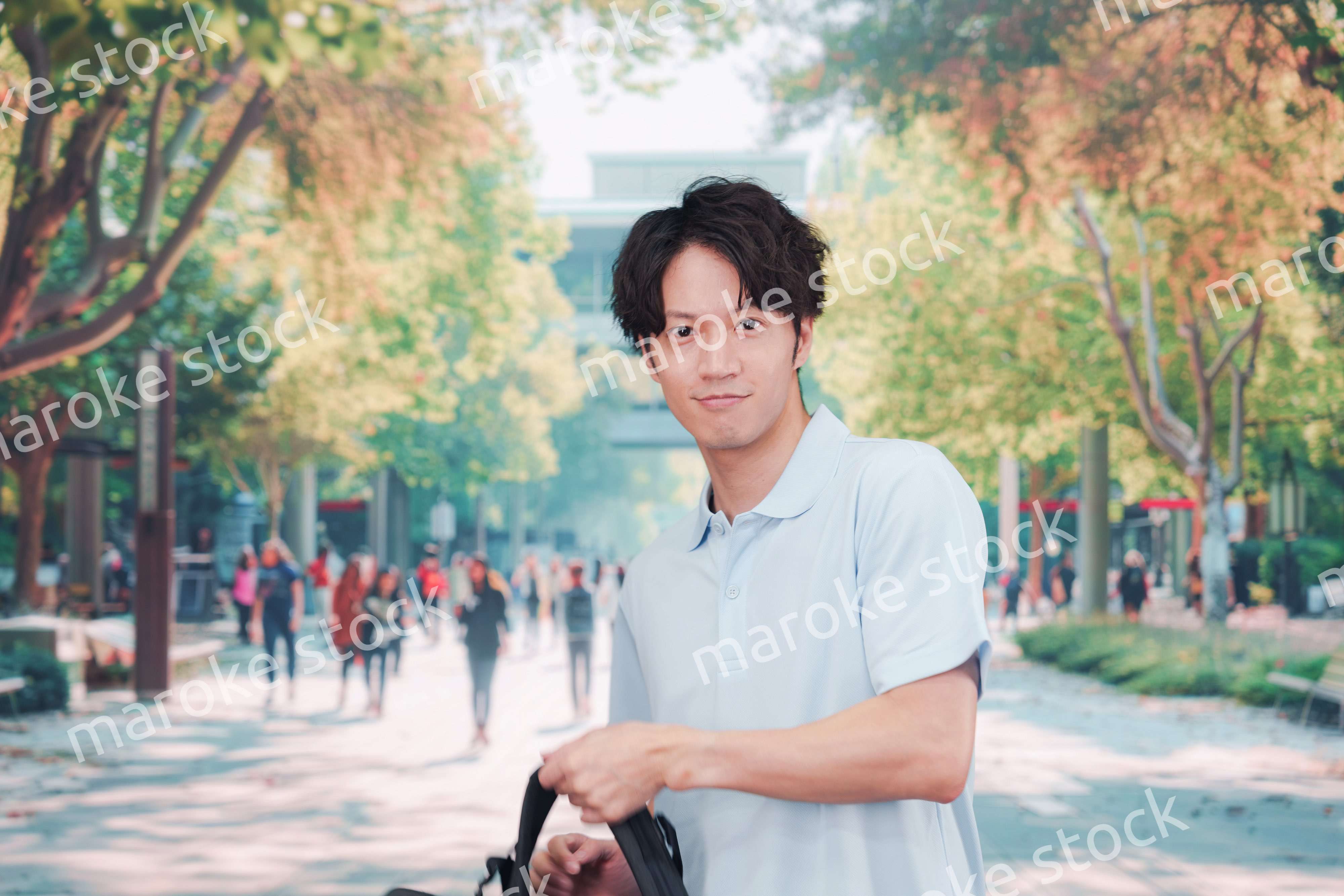 笑顔でキャンパスを歩く大学生の男性