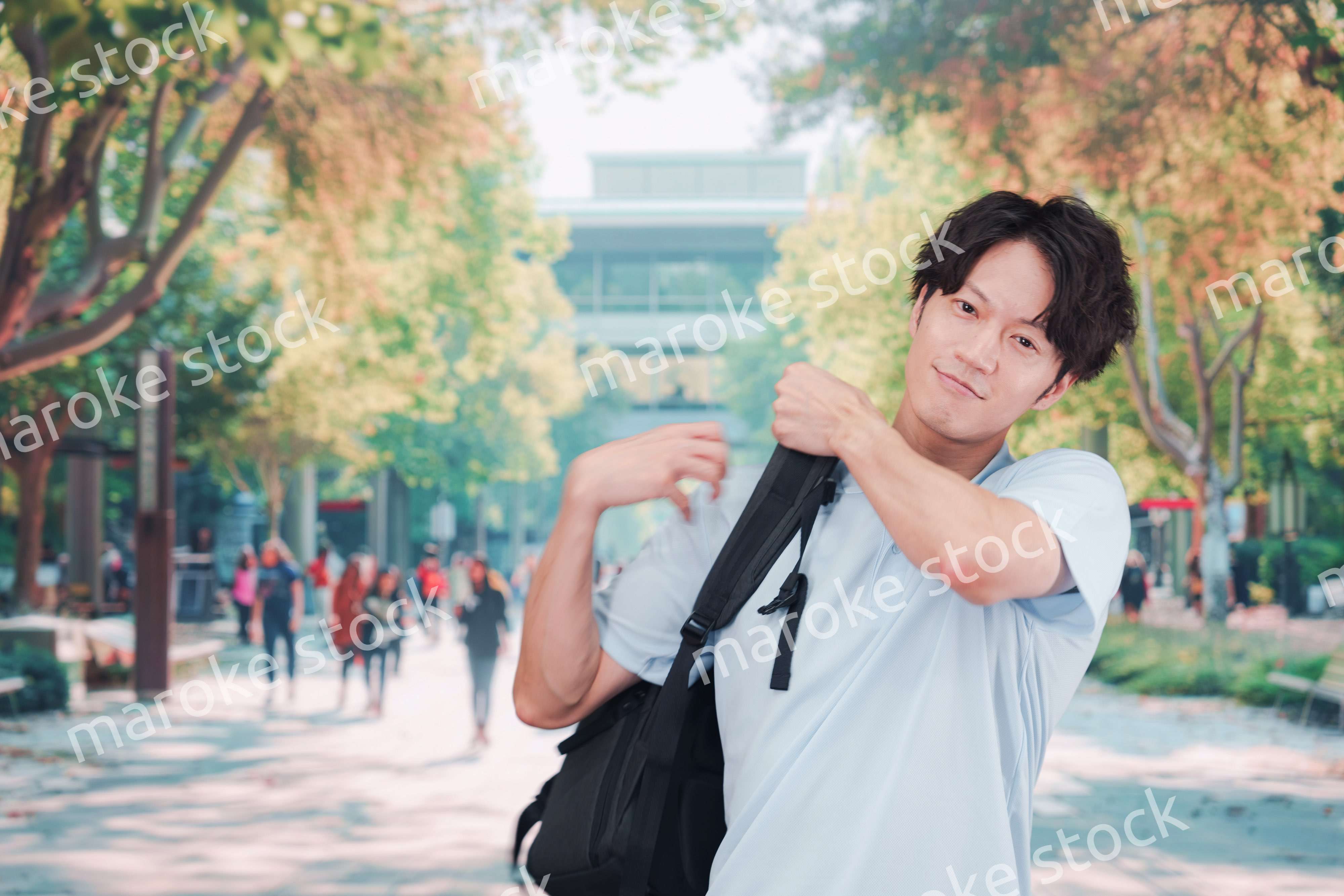 笑顔でキャンパスを歩く大学生の男性