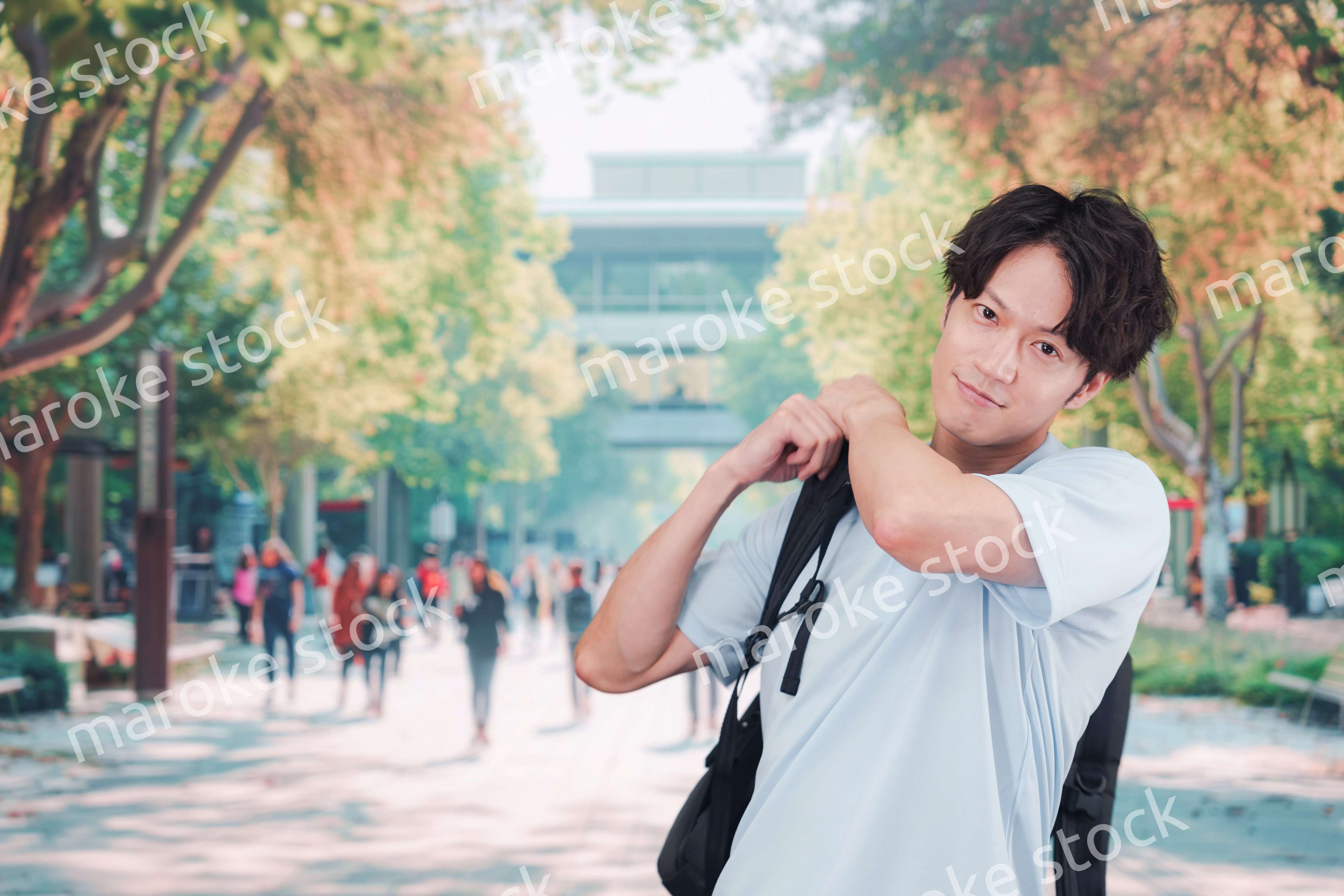 笑顔でキャンパスを歩く大学生の男性