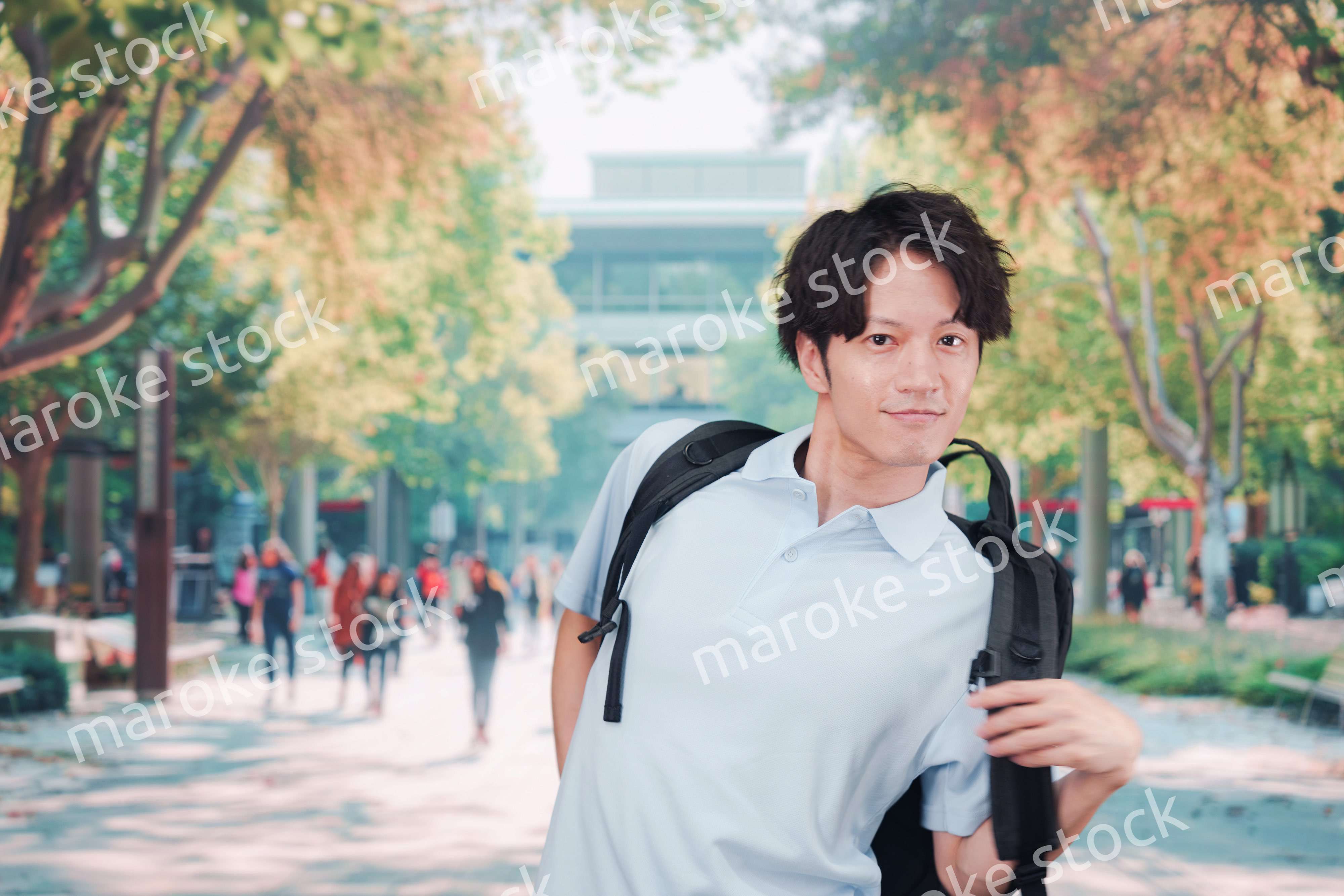 笑顔でキャンパスを歩く大学生の男性