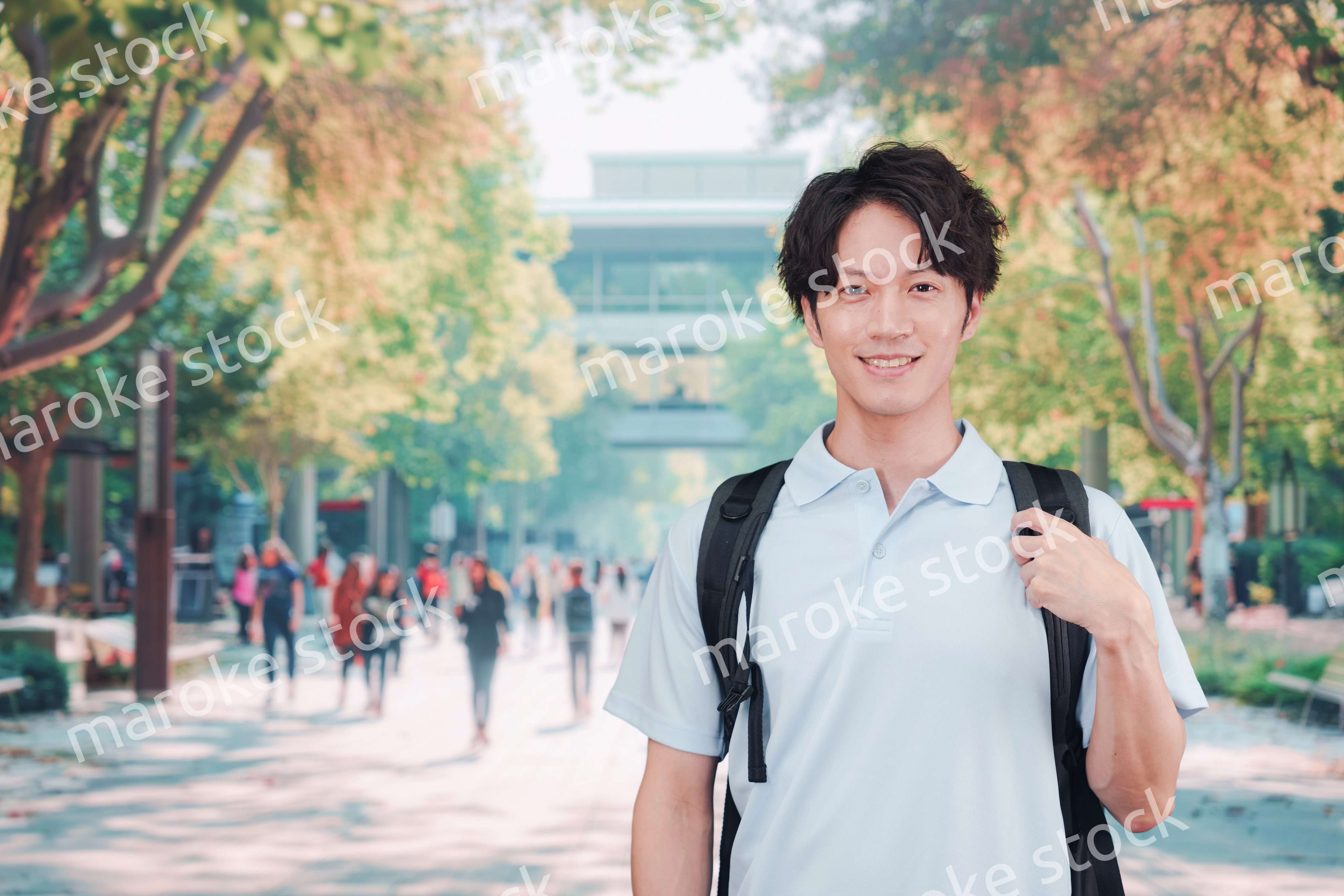 笑顔でキャンパスを歩く大学生の男性