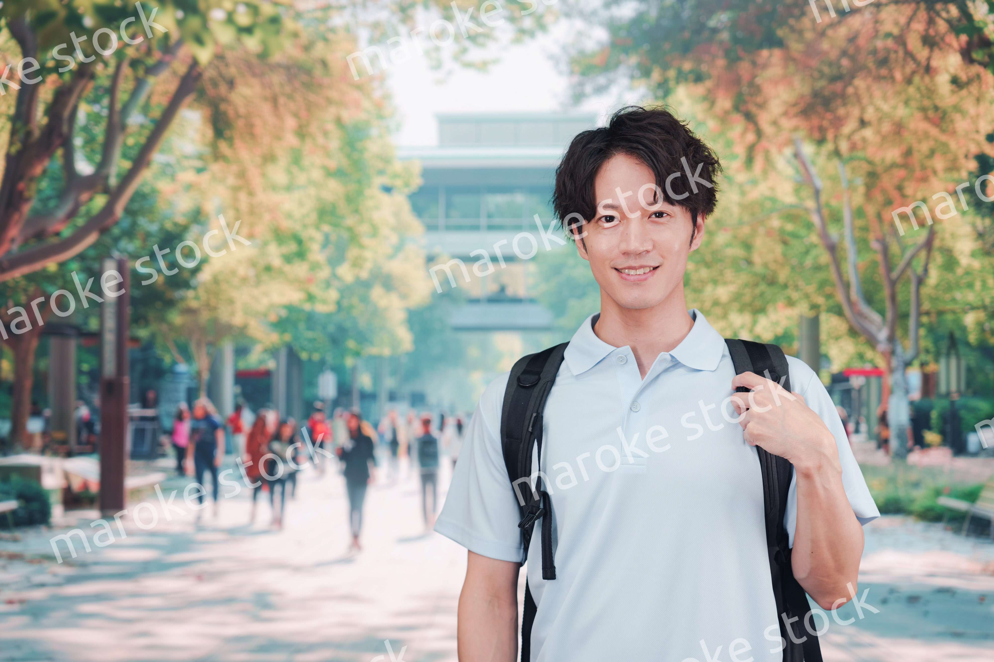 笑顔でキャンパスを歩く大学生の男性