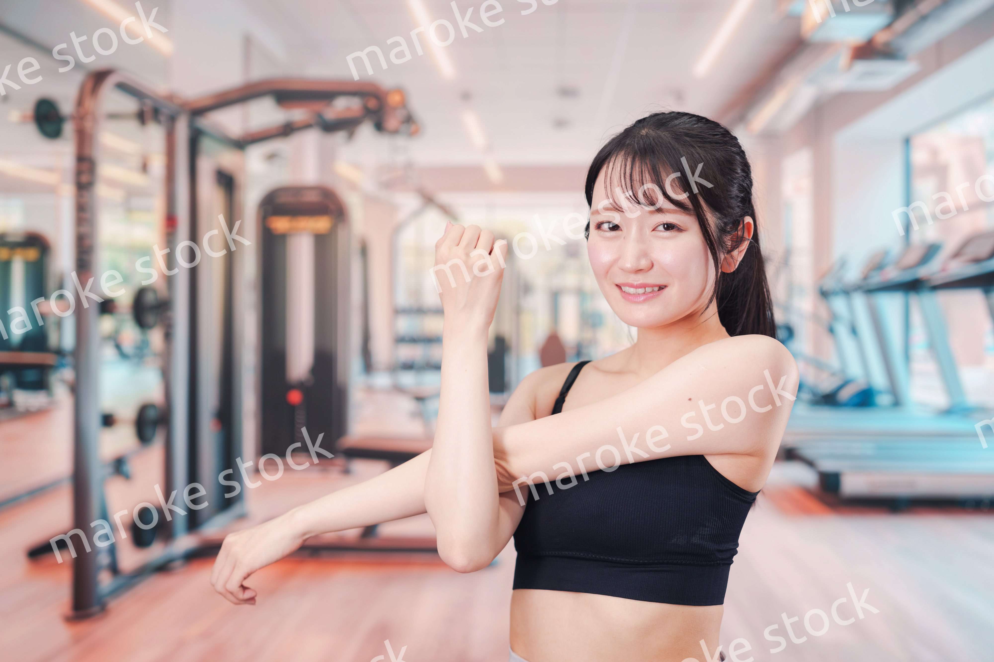 ジムでストレッチをする若い女性