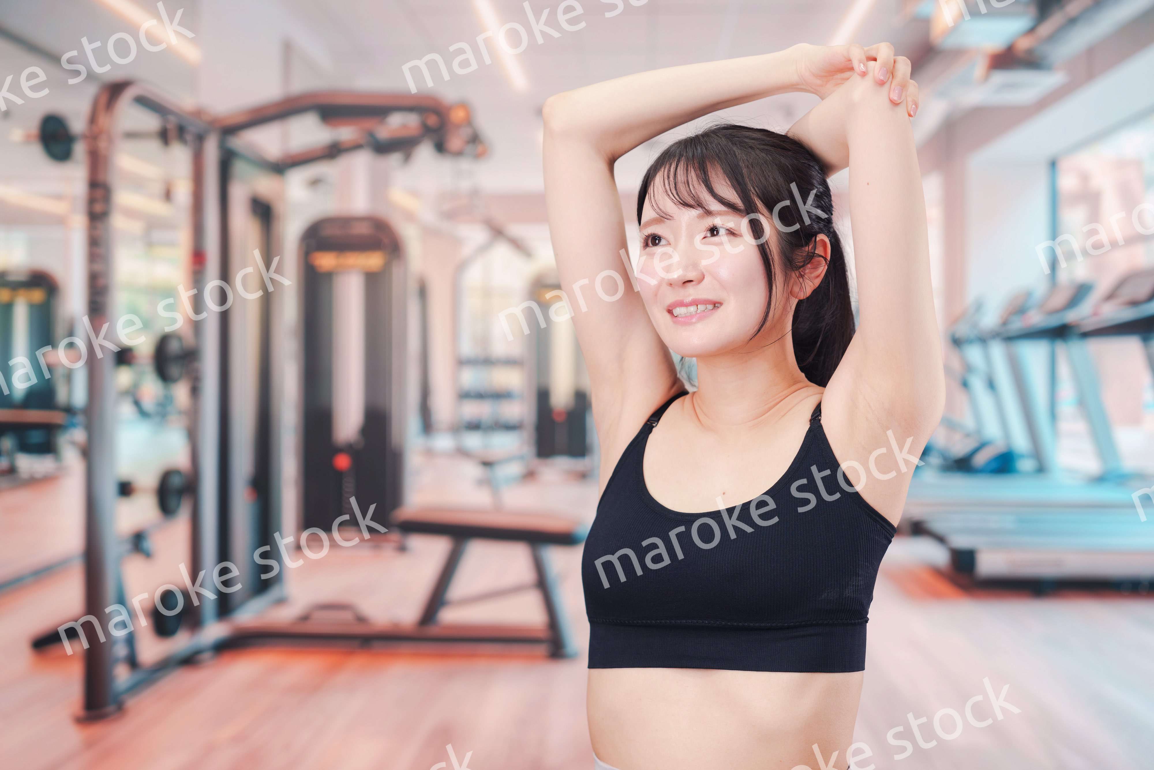 ジムでストレッチをする若い女性