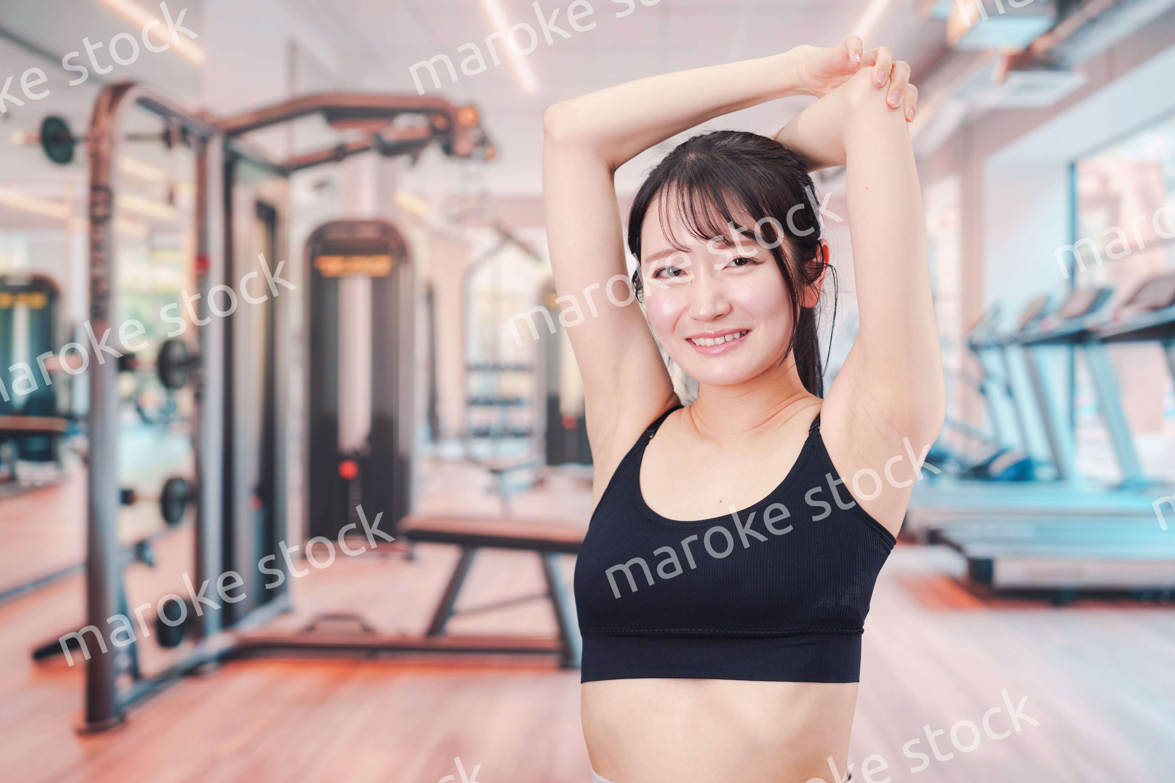 ジムでストレッチをする若い女性