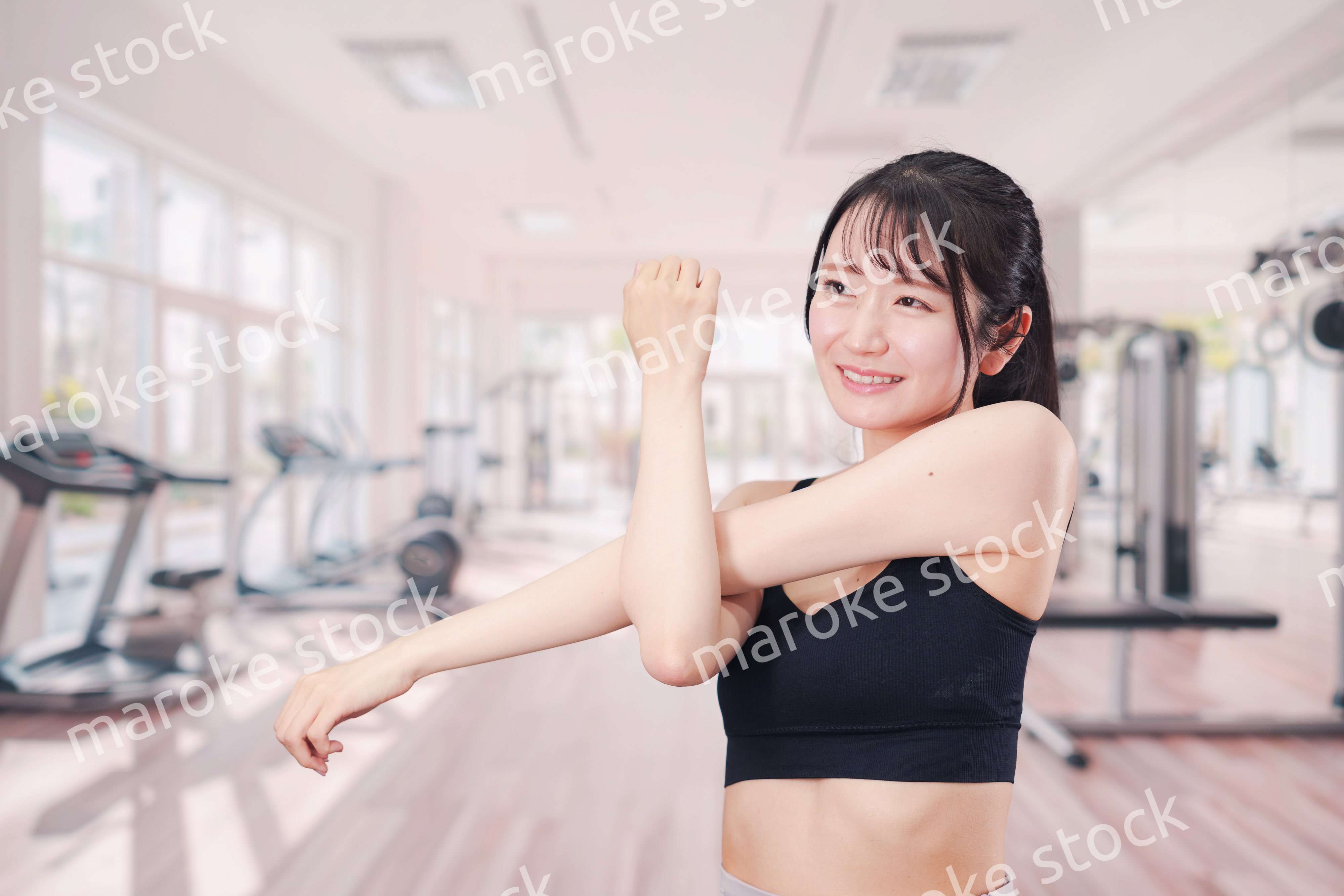 ジムでストレッチをする若い女性