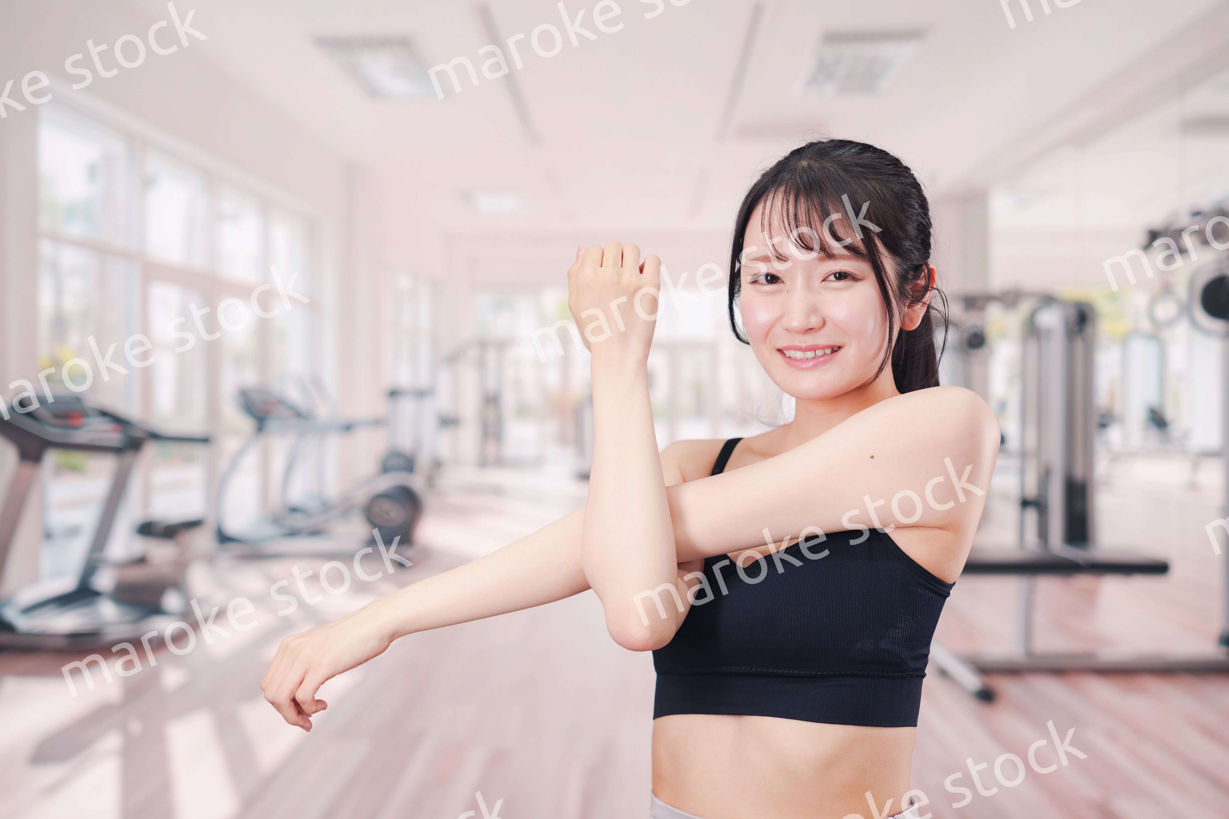 ジムでストレッチをする若い女性