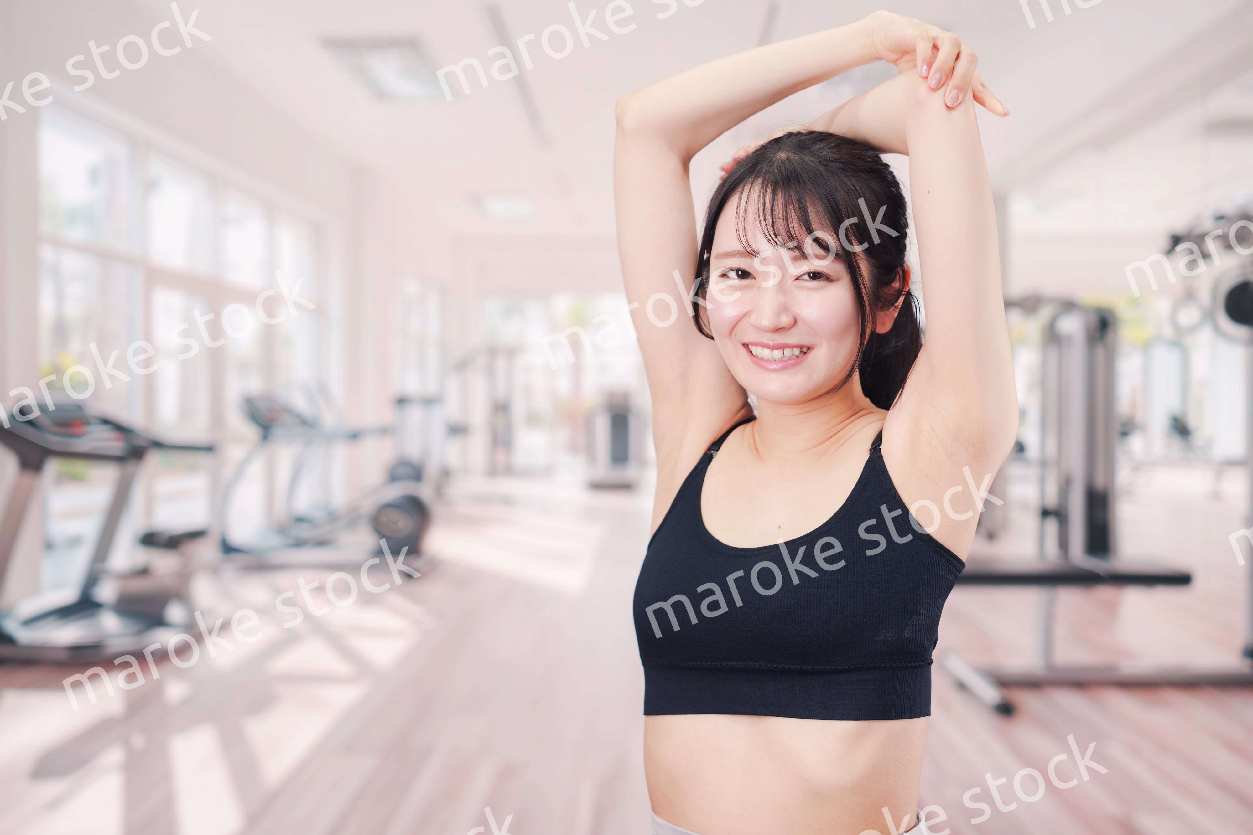 ジムでストレッチをする若い女性