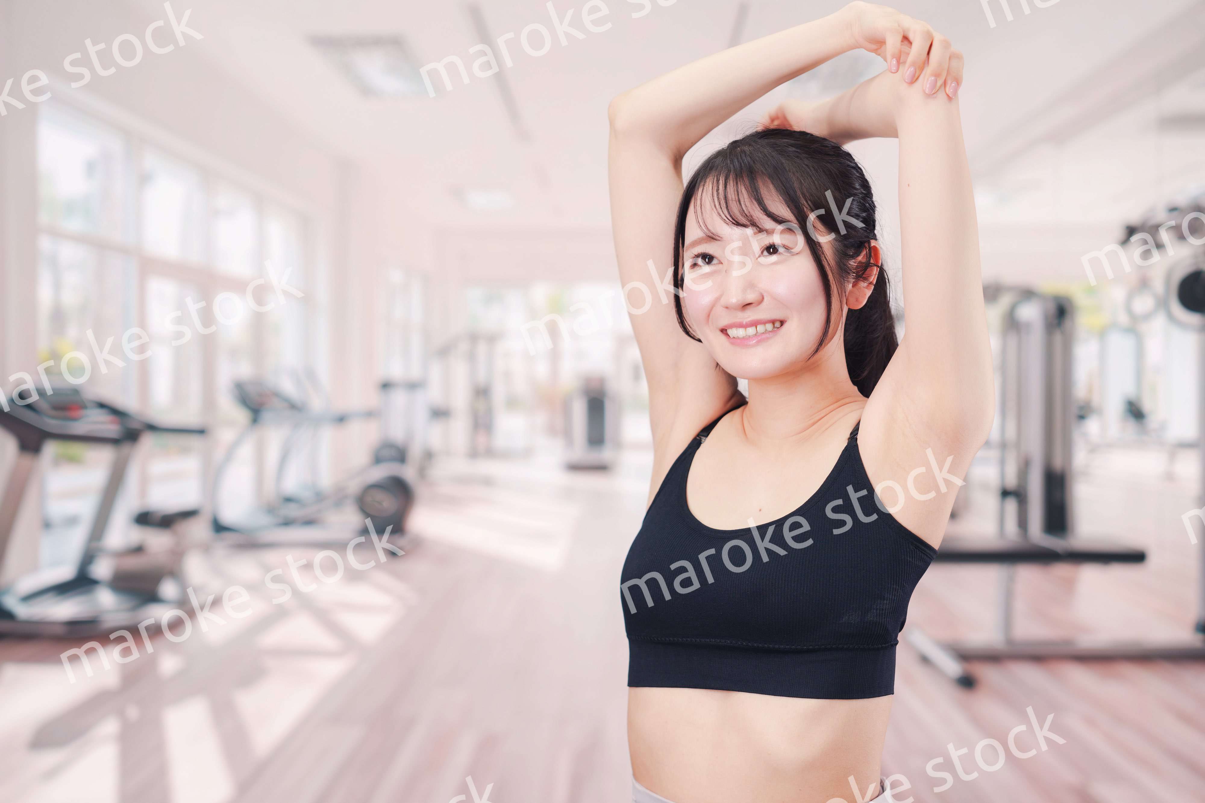 ジムでストレッチをする若い女性