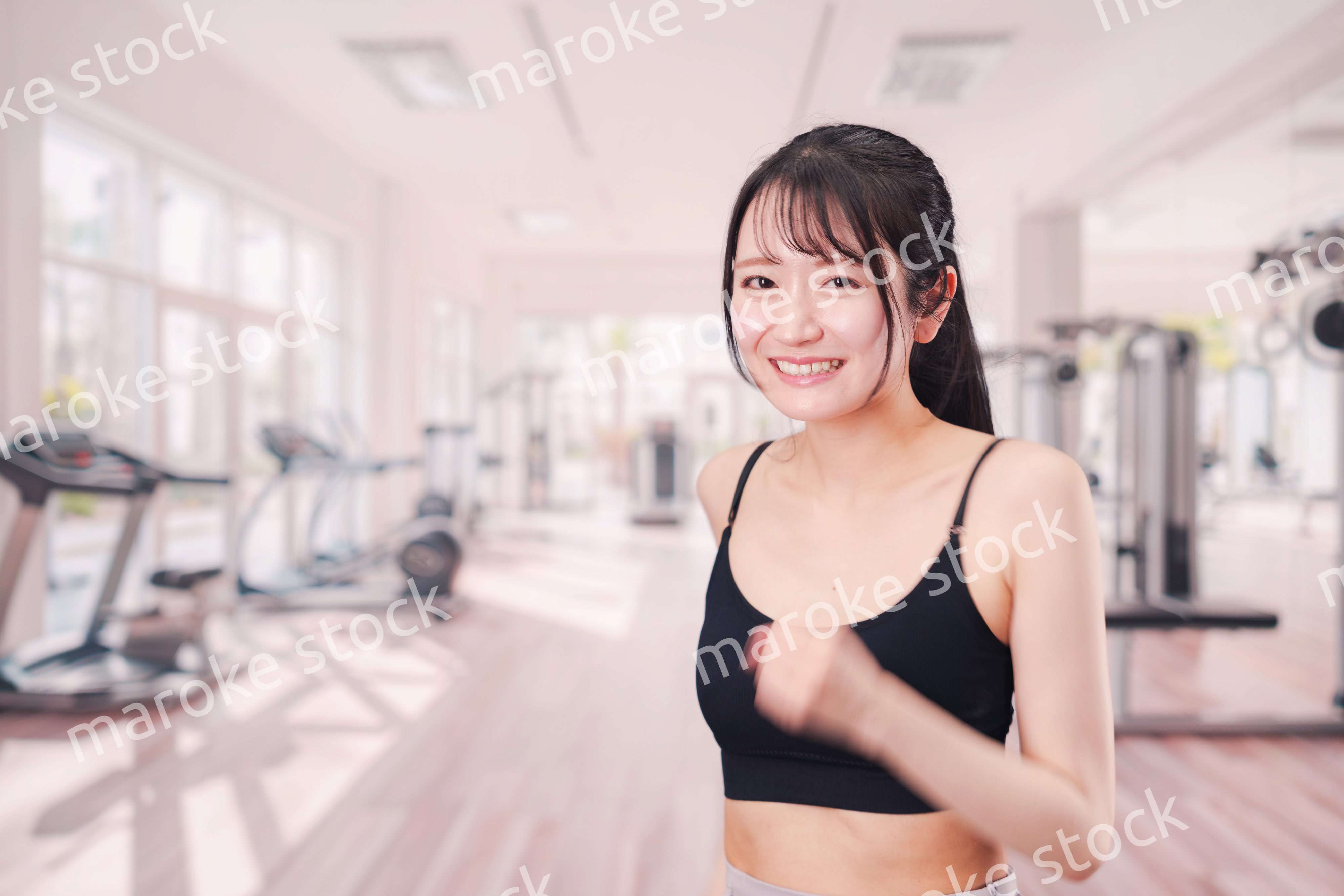 ジムでランニングをする若い女性