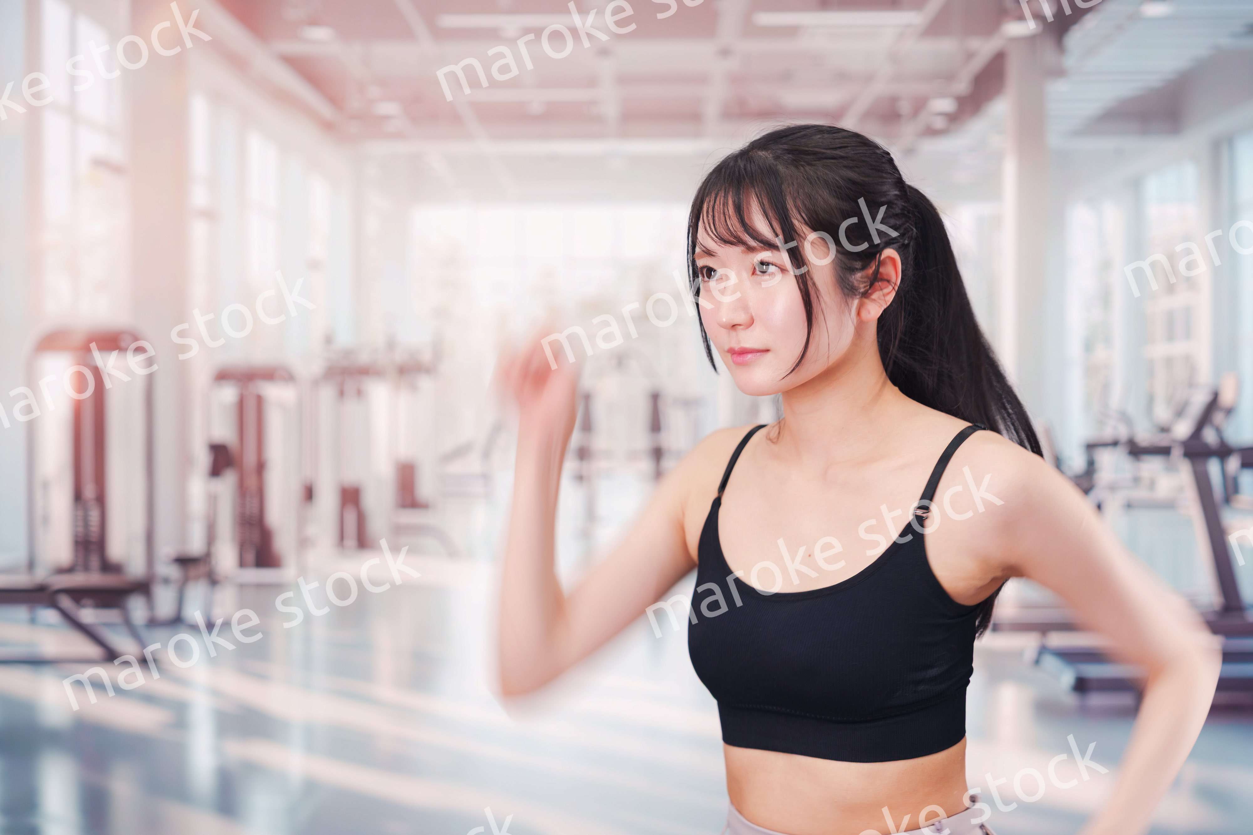 ジムでランニングをする若い女性