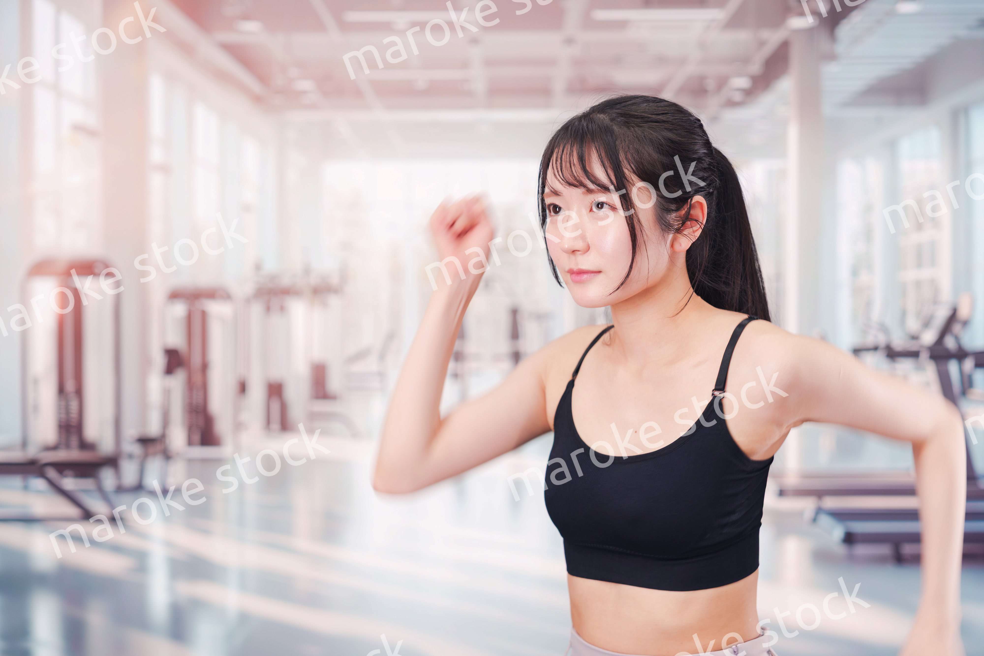 ジムでランニングをする若い女性