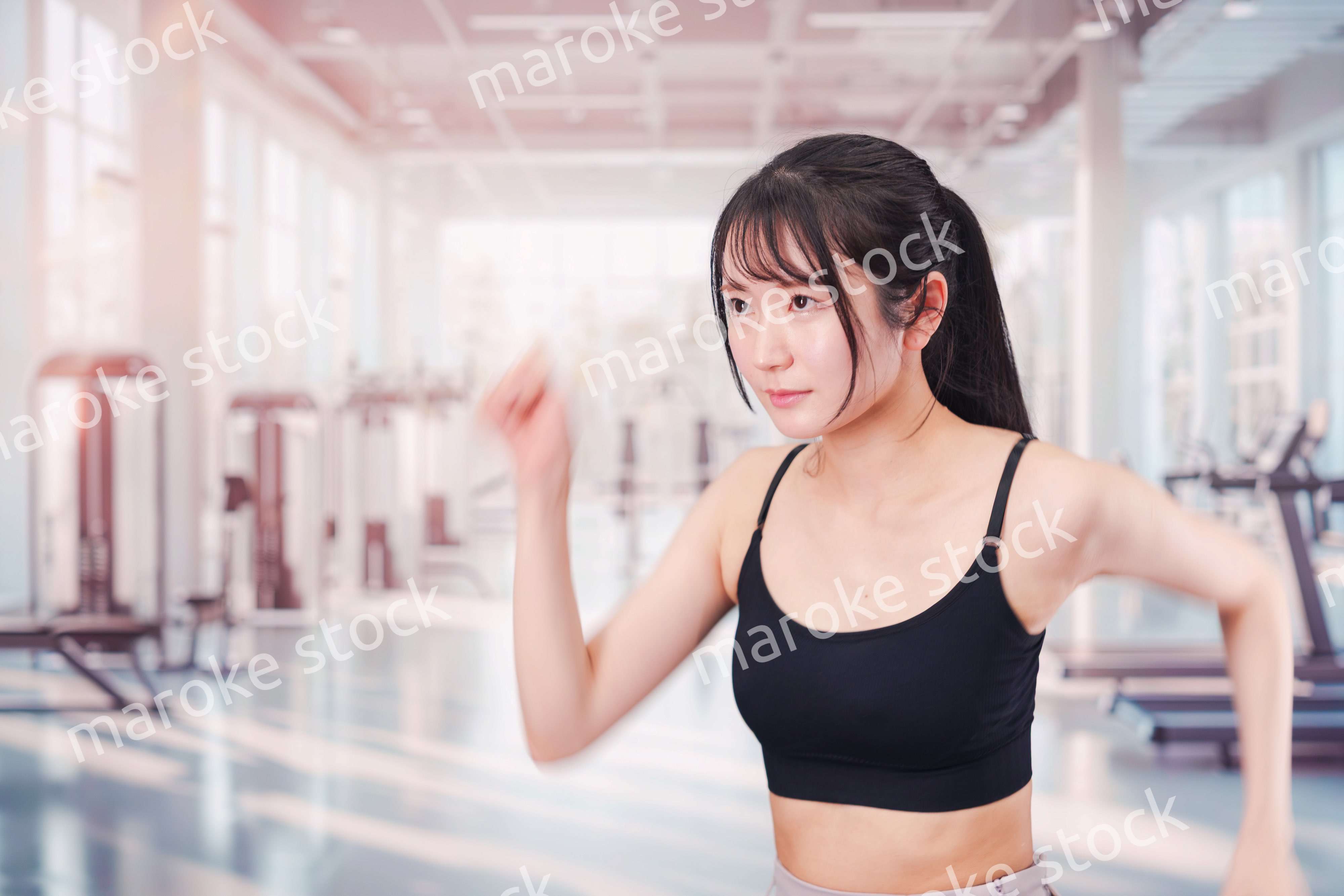 ジムでランニングをする若い女性