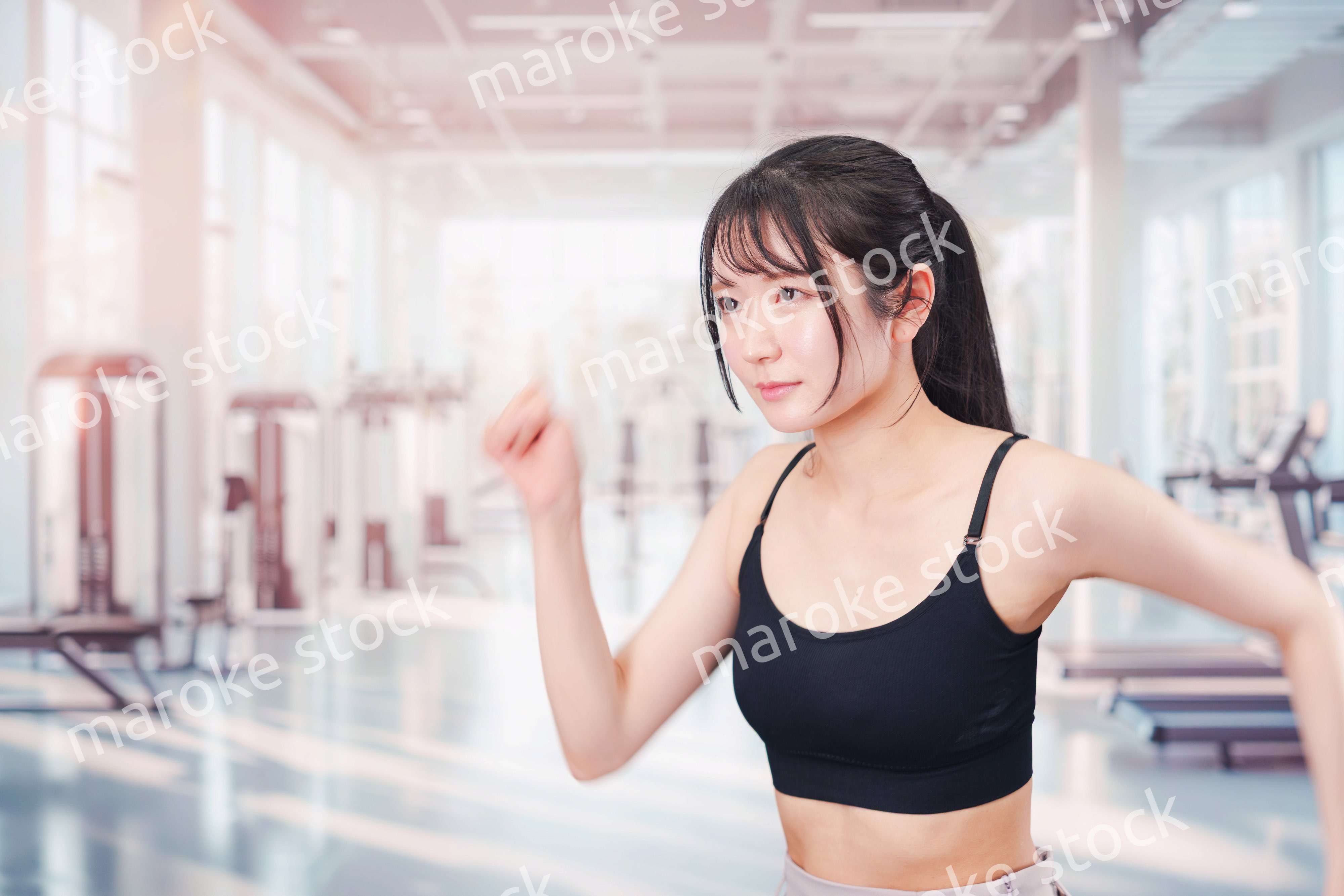 ジムでランニングをする若い女性