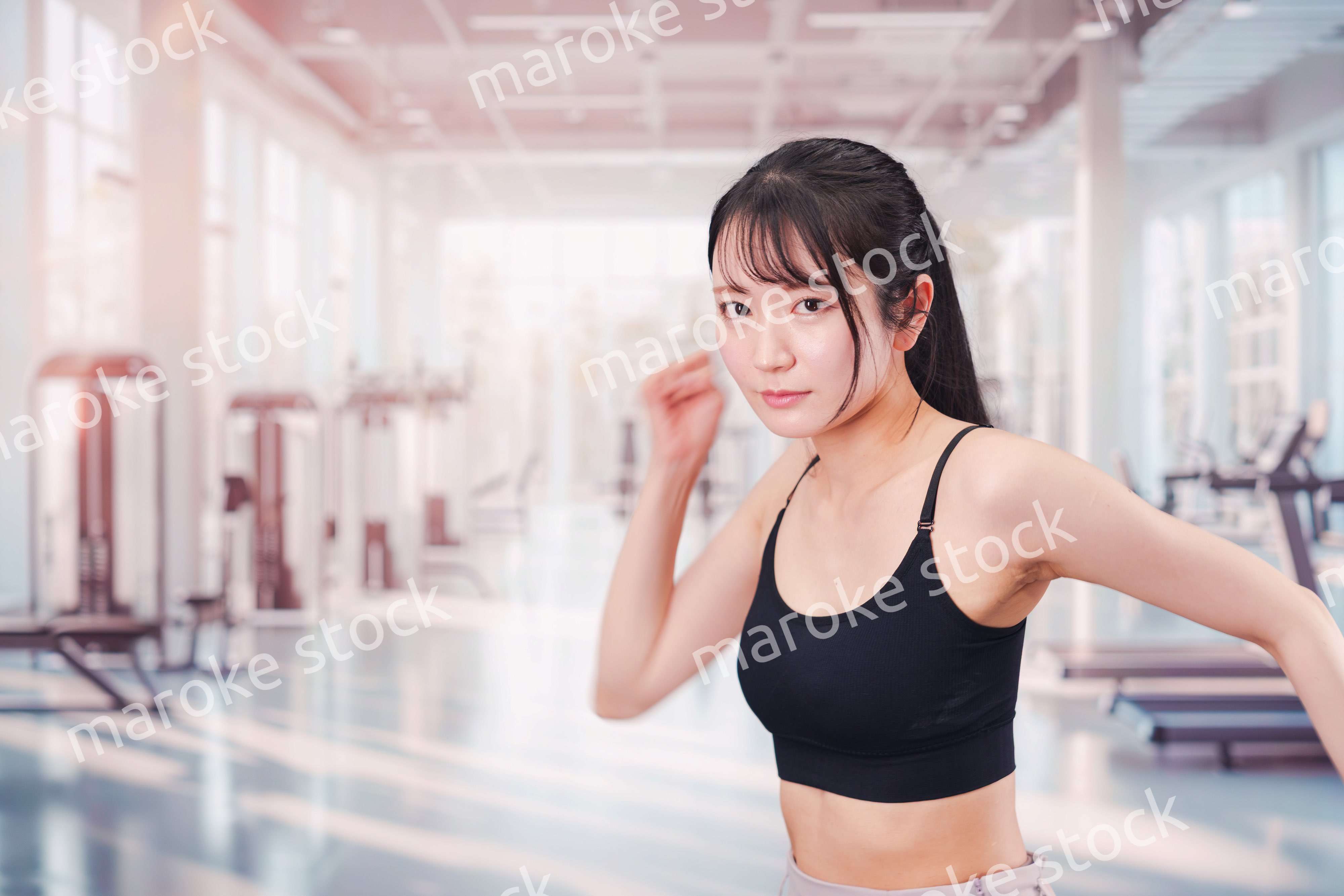 ジムでランニングをする若い女性