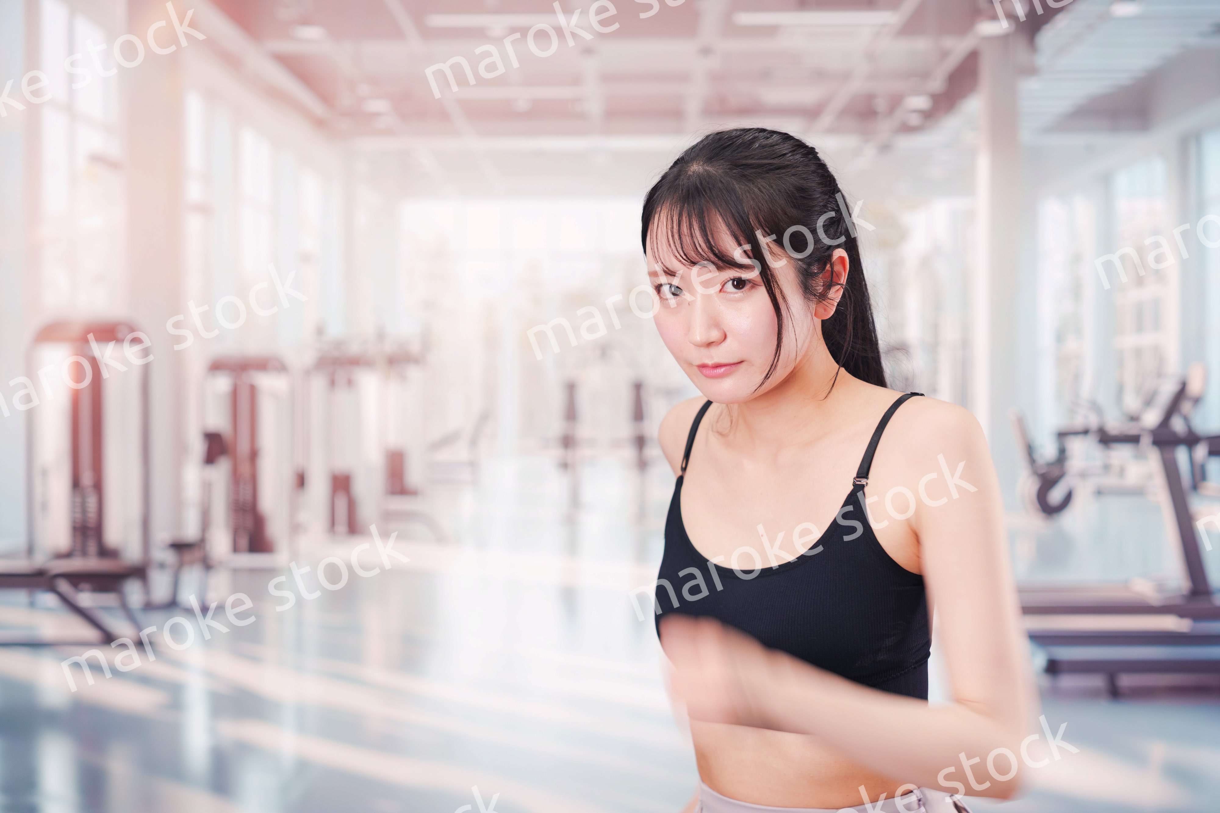 ジムでランニングをする若い女性