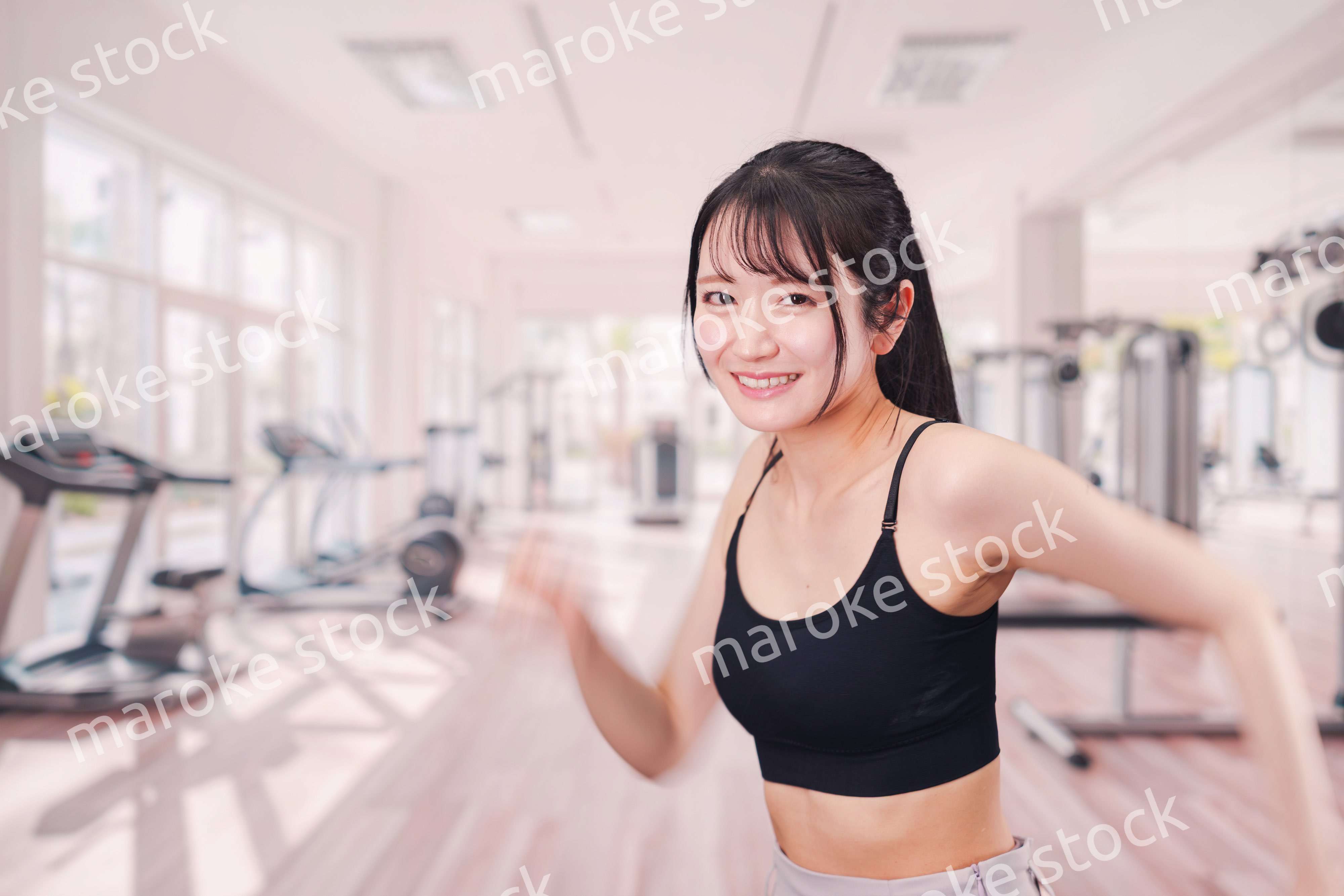 ジムでランニングをする若い女性