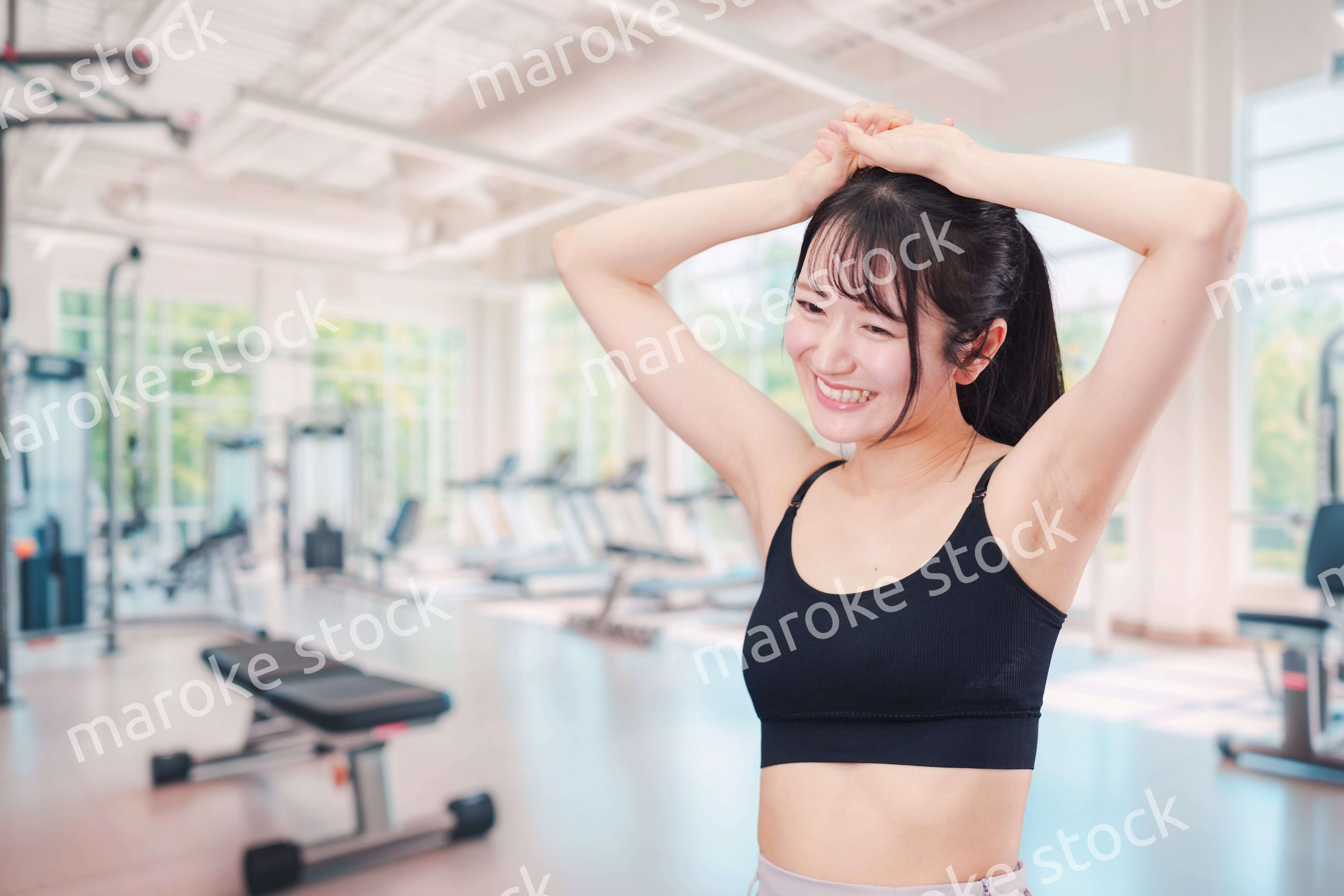 ジムでストレッチをする若い女性