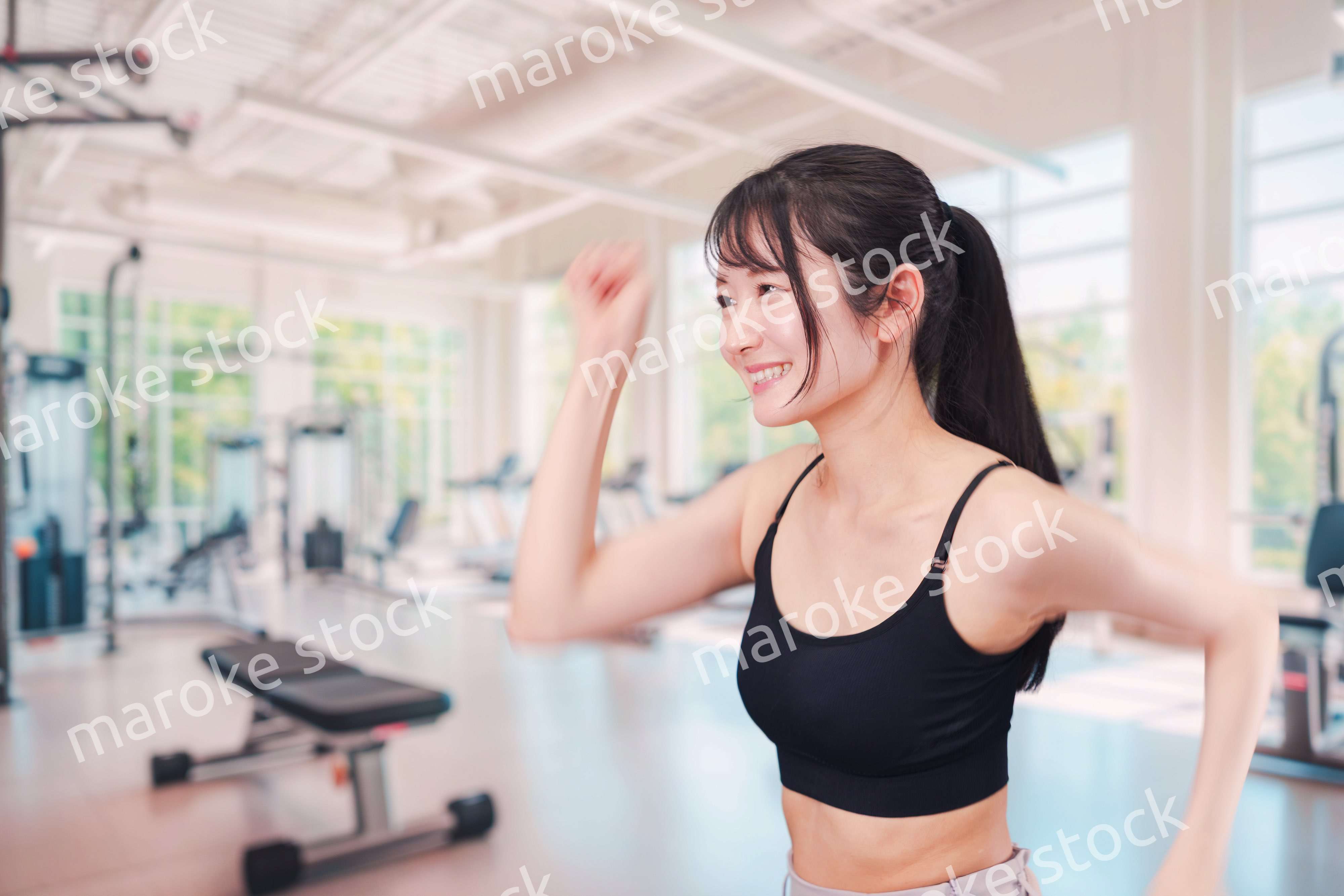 ジムでランニングをする若い女性