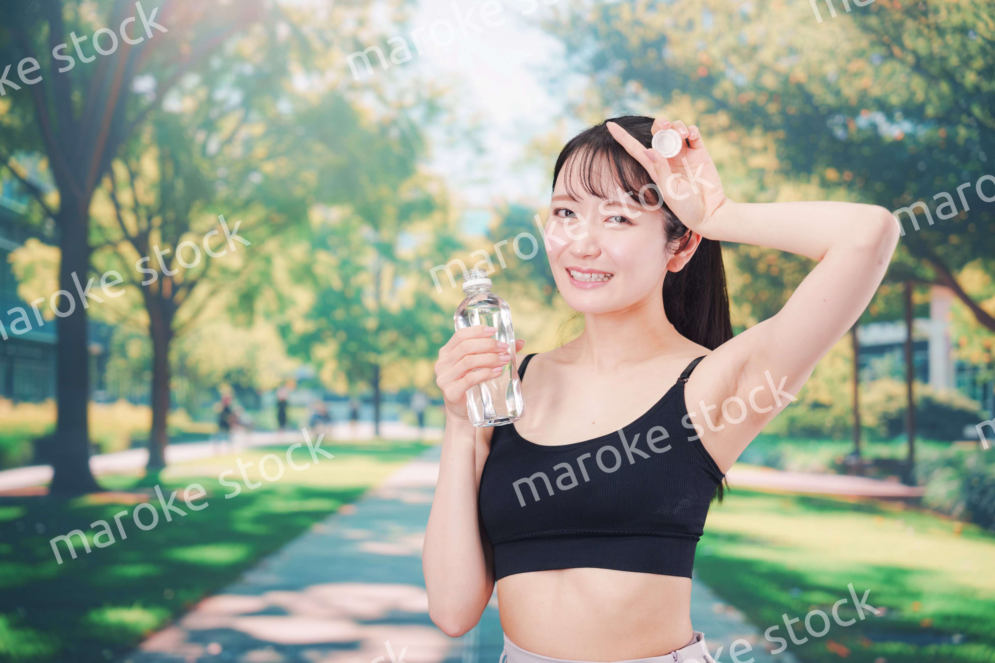 外でランニングをしながら水を飲む若い女性