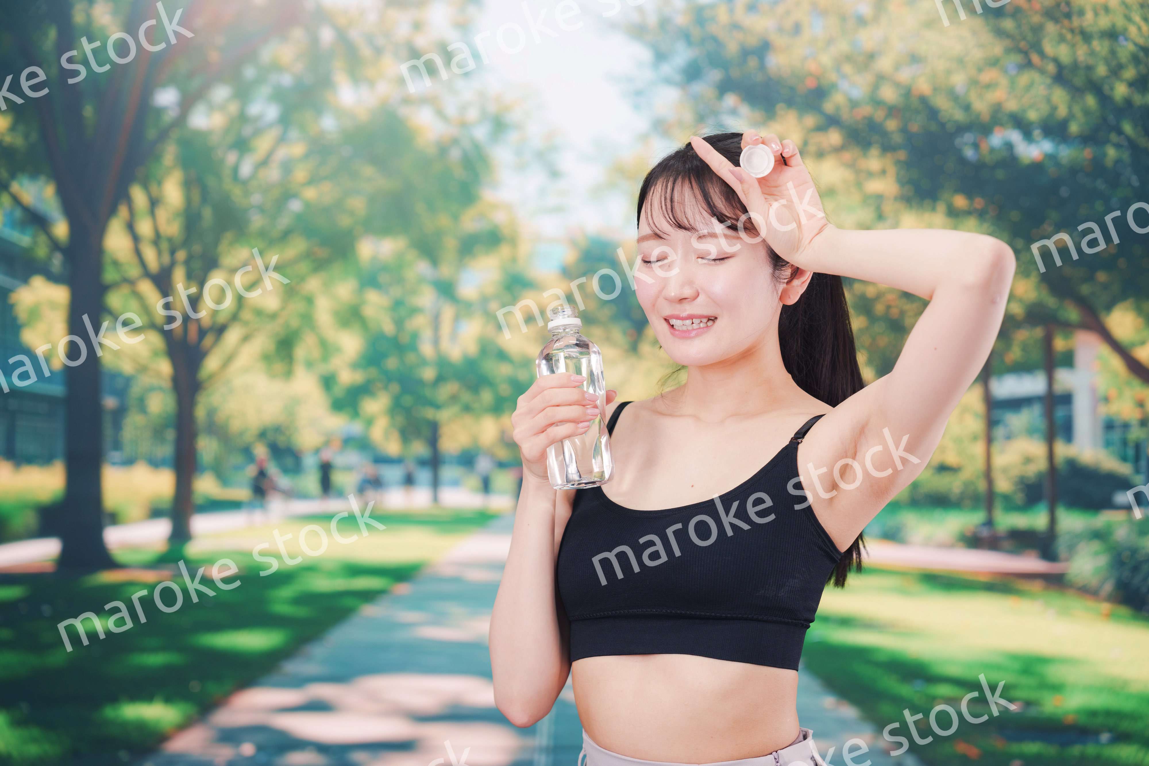 外でランニングをしながら水を飲む若い女性