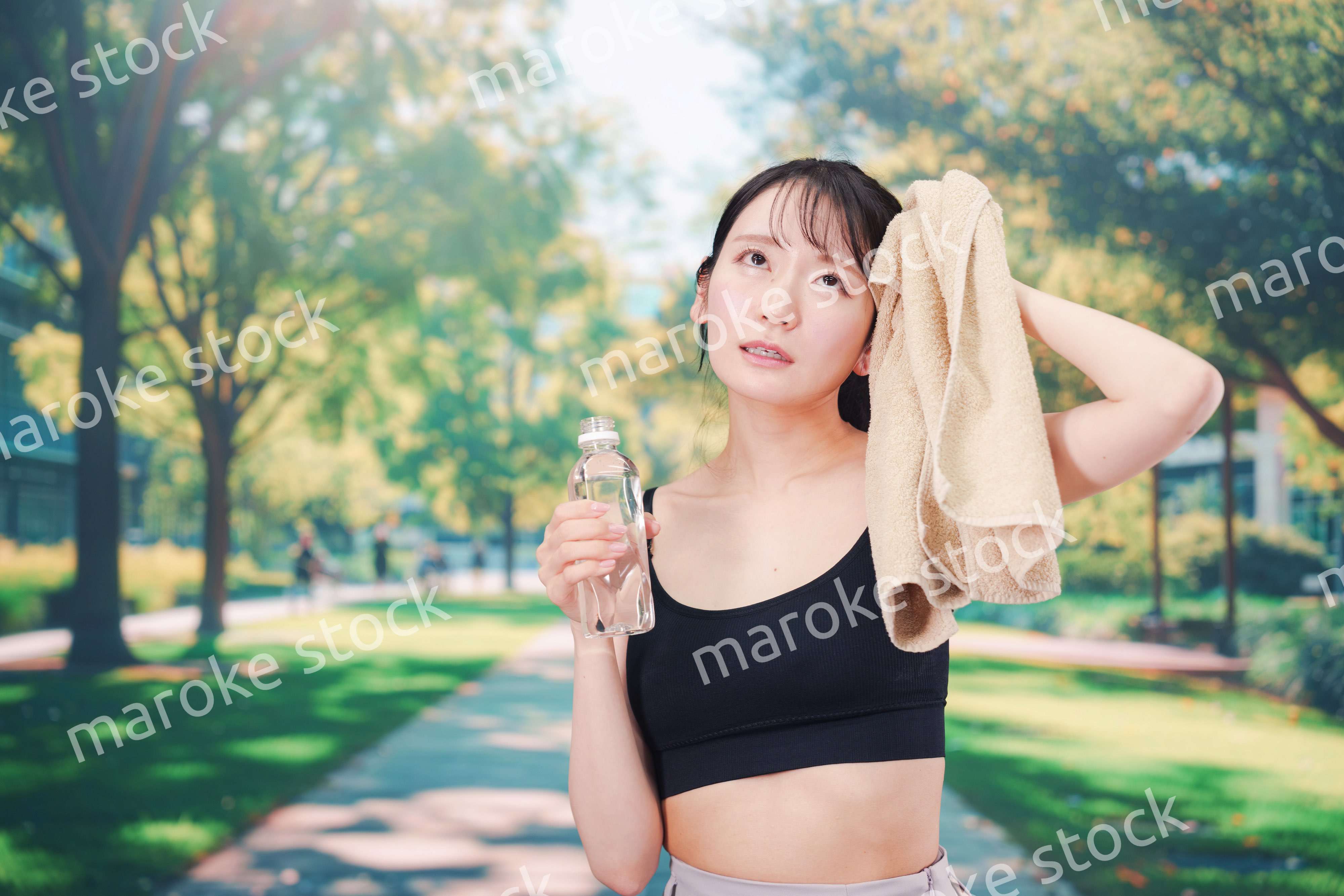 外でランニングをしながら水を飲む若い女性