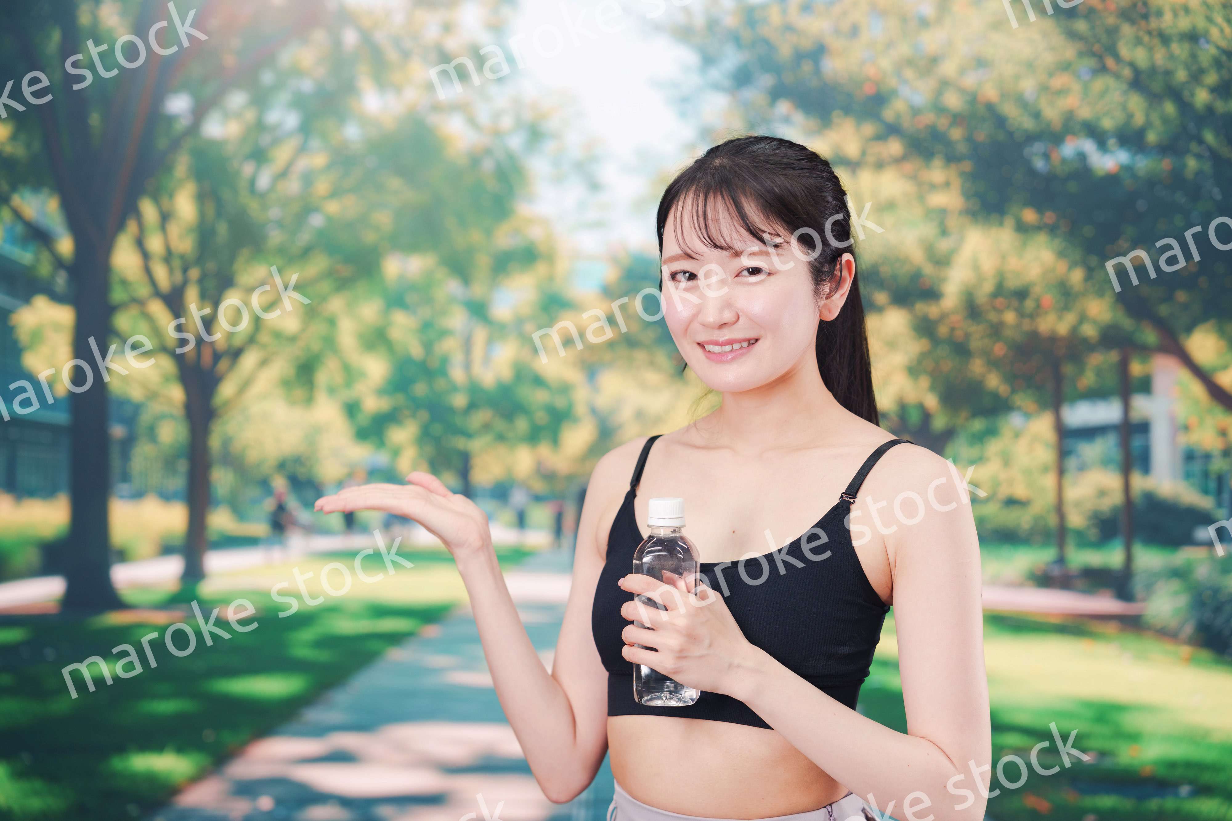 外でランニングをしながら水を飲む若い女性