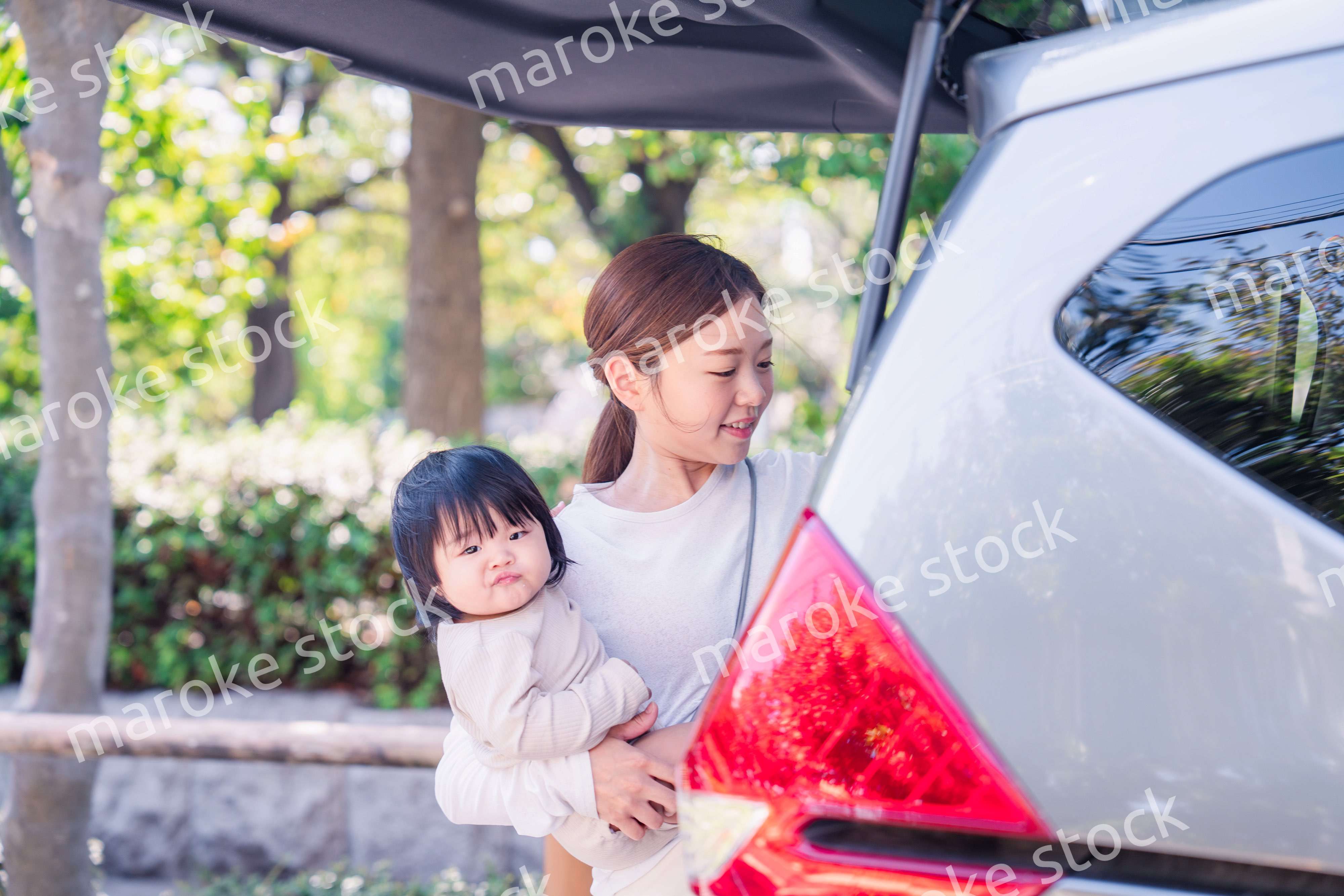 赤ちゃんと一緒に車に乗るお母さん