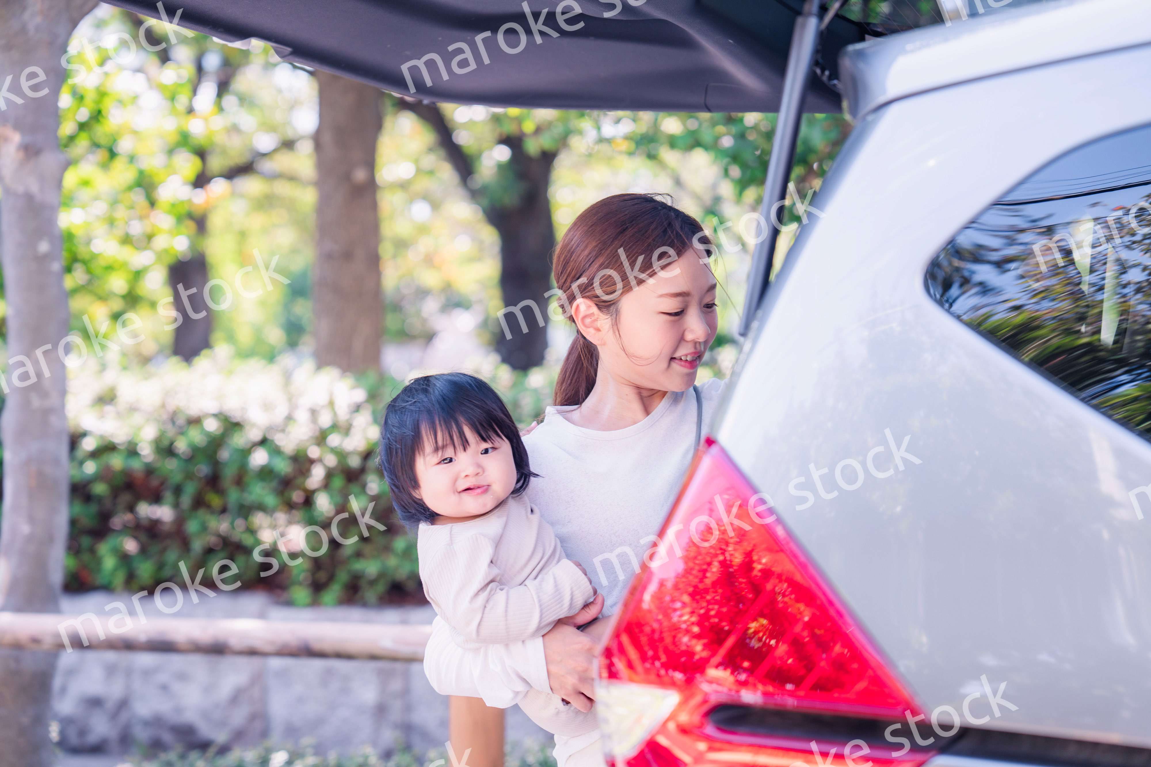 赤ちゃんと一緒に車に乗るお母さん