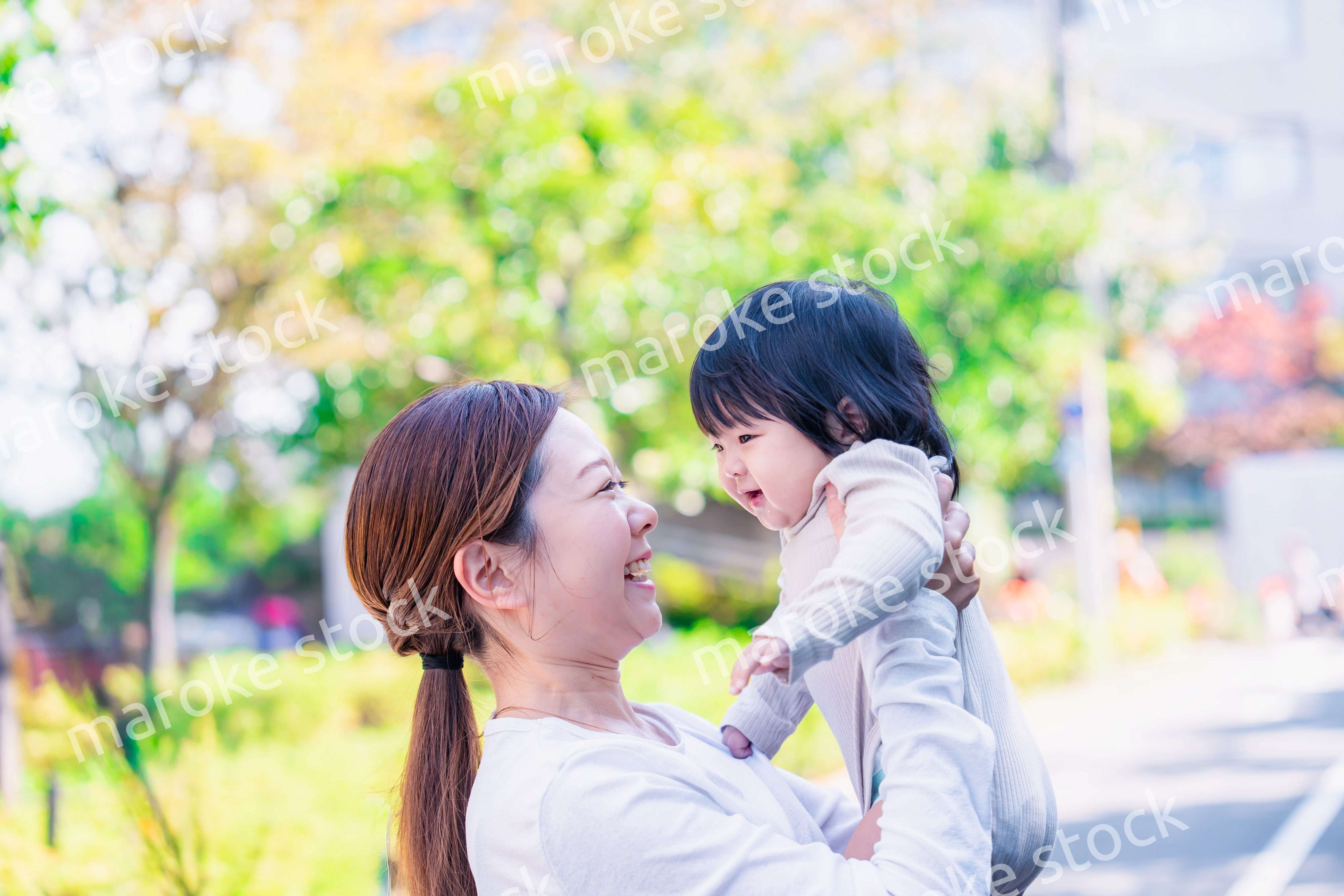 生後半年の赤ちゃんを抱っこして笑うお母さん