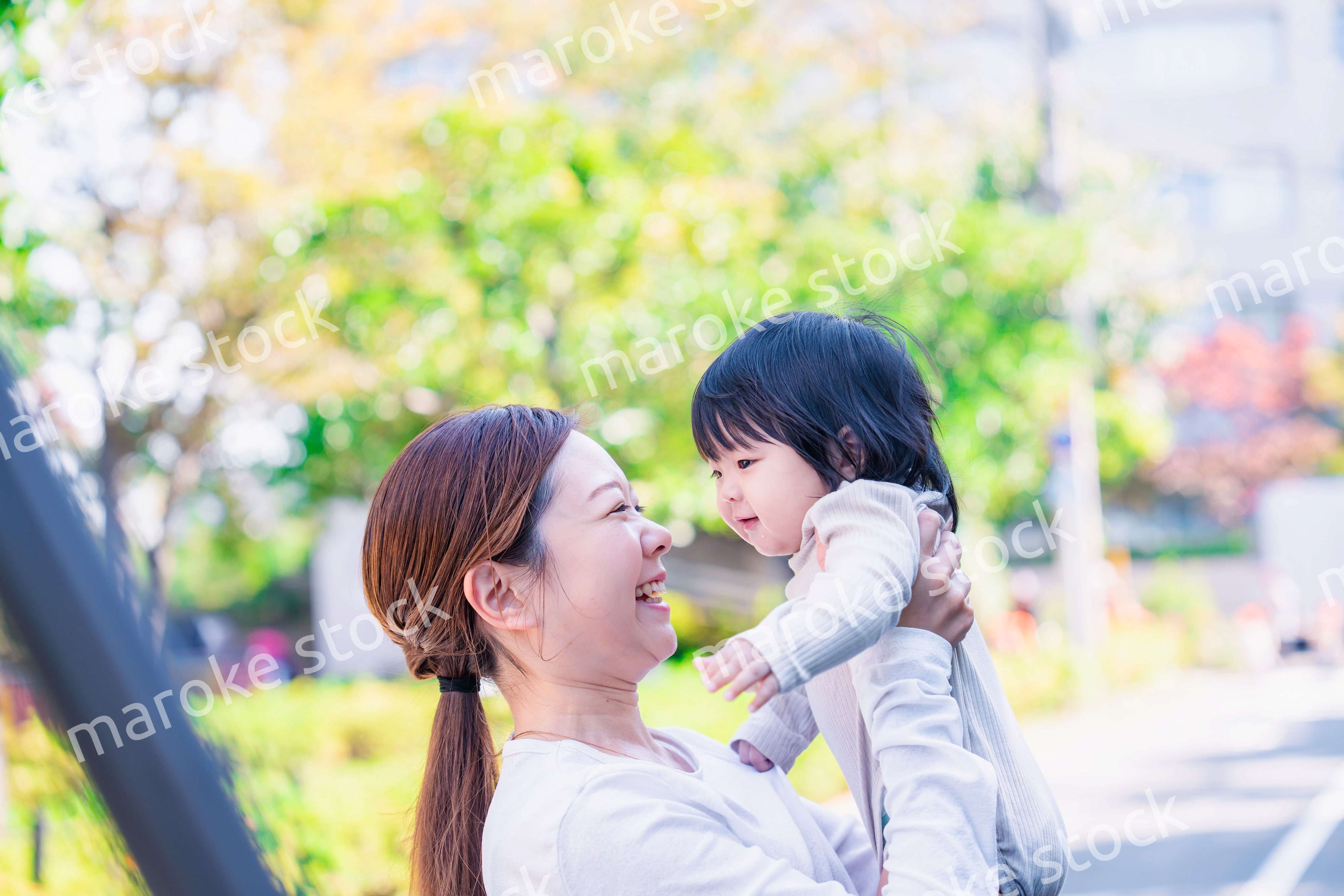 生後半年の赤ちゃんを抱っこして笑うお母さん
