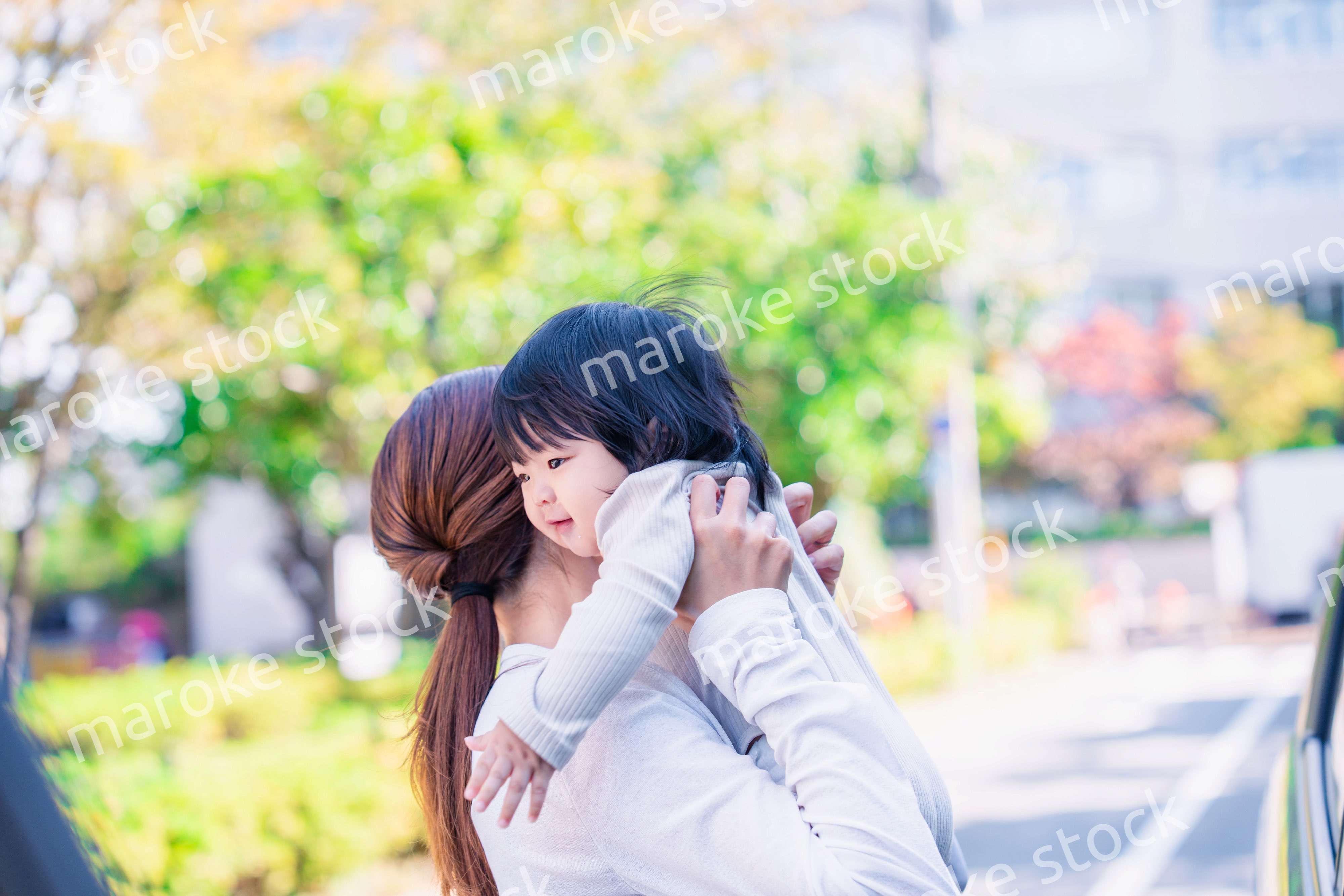 生後半年の赤ちゃんを抱っこして笑うお母さん