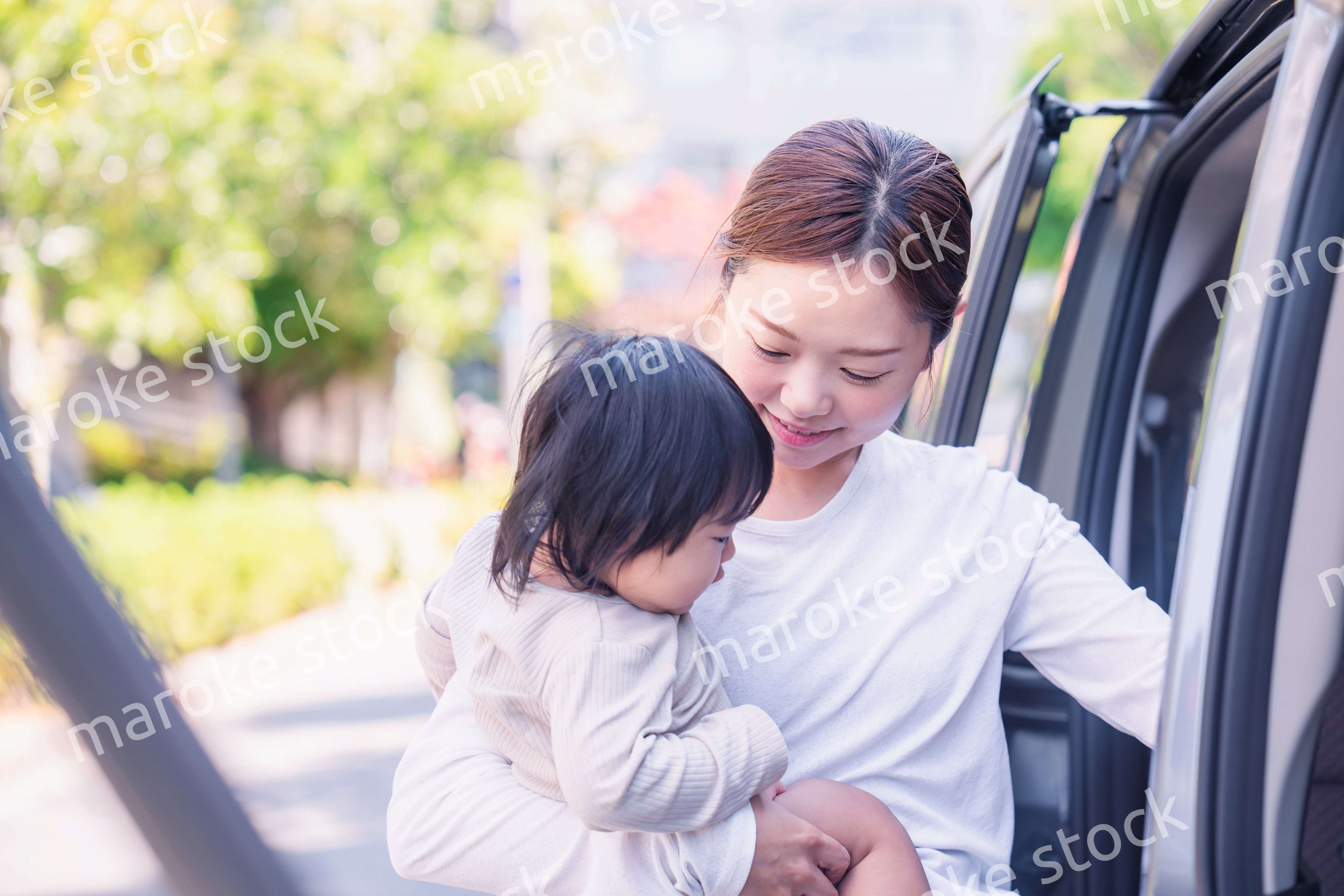 赤ちゃんと一緒に車に乗るお母さん