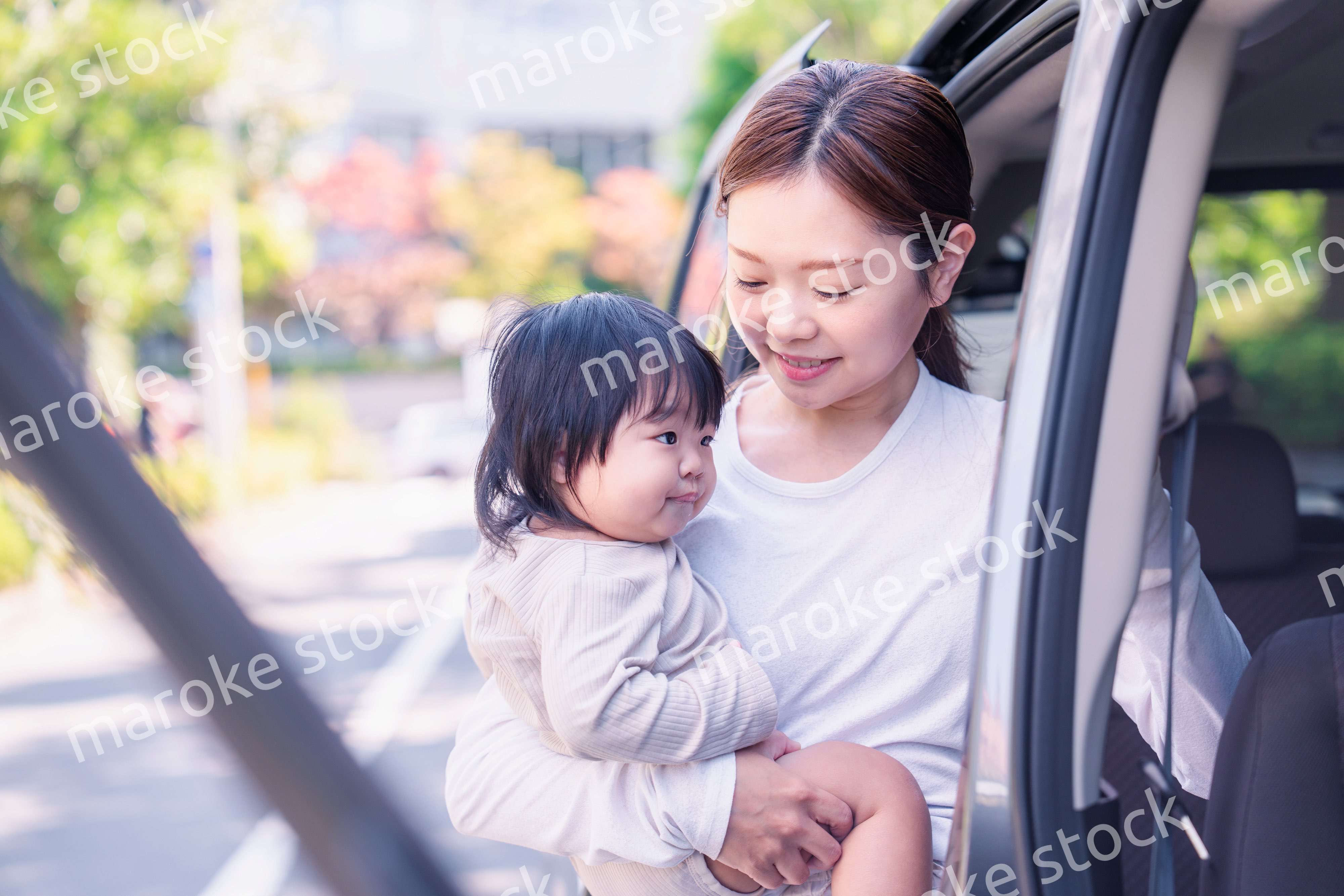 赤ちゃんと一緒に車に乗るお母さん