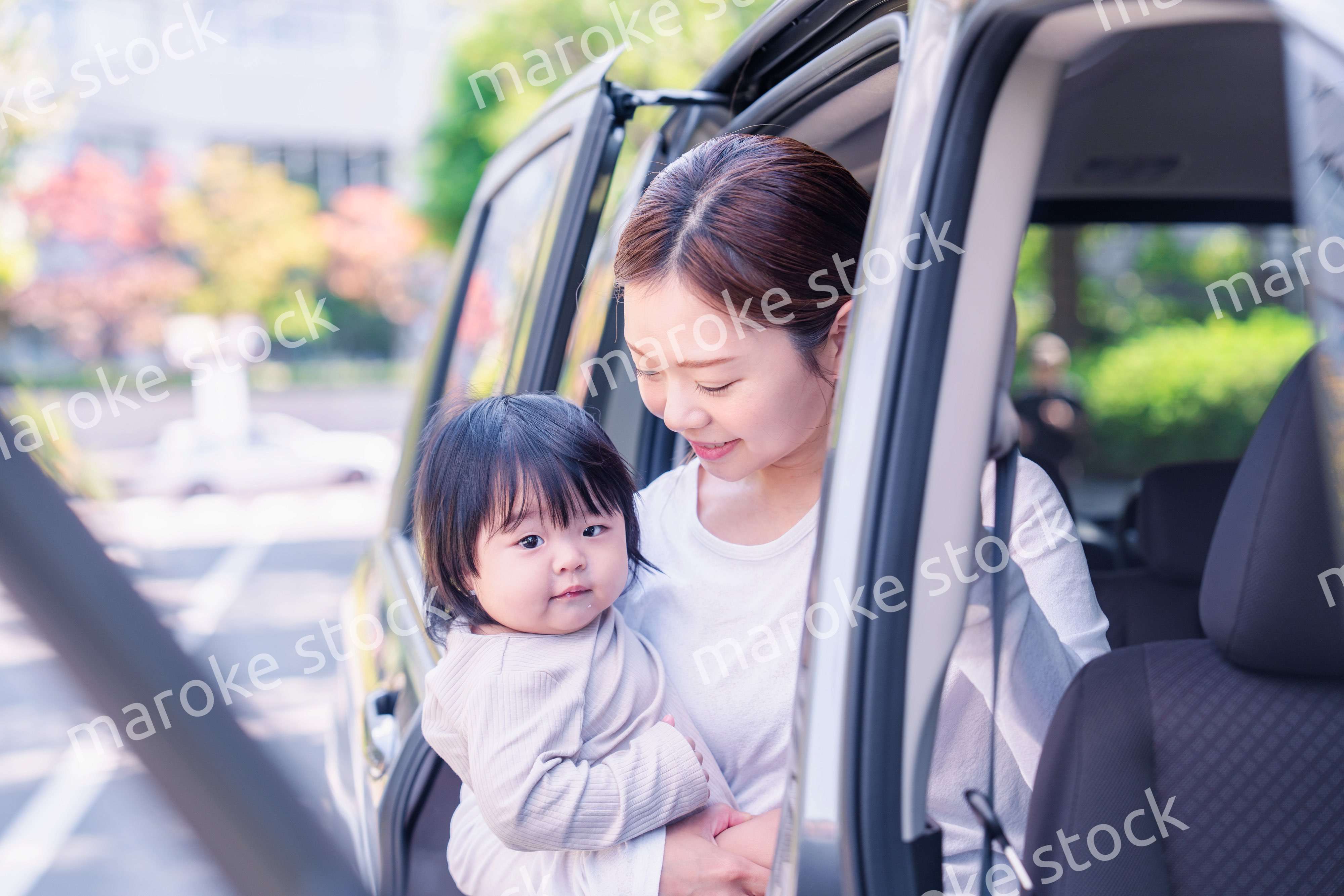 赤ちゃんと一緒に車に乗るお母さん