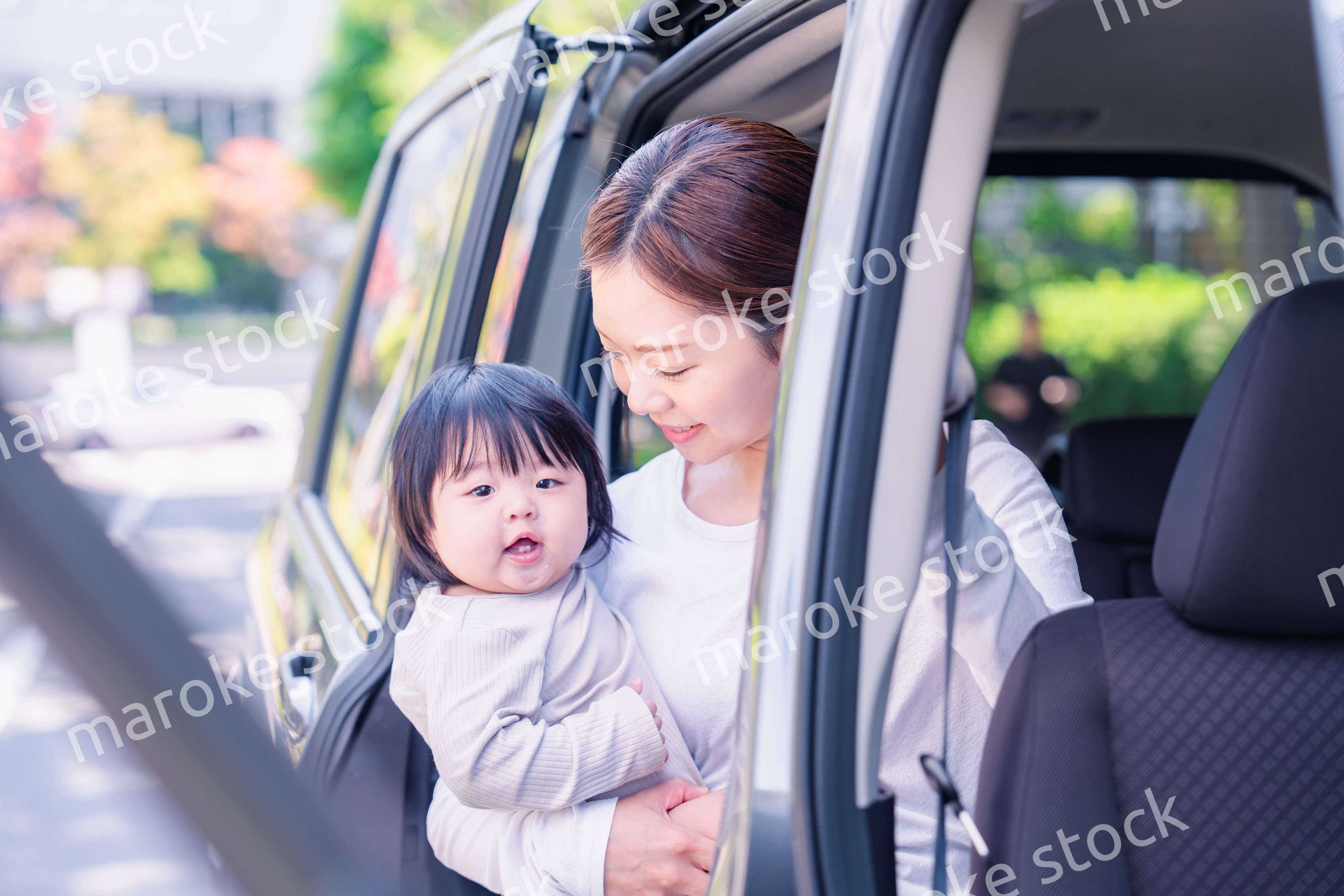 赤ちゃんと一緒に車に乗るお母さん