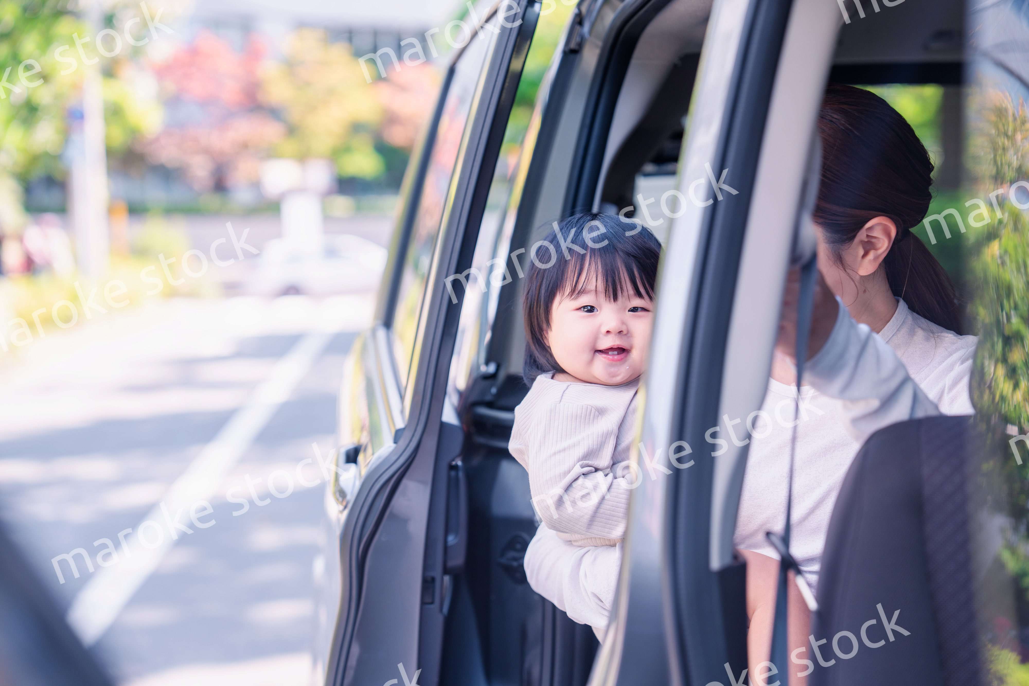 赤ちゃんと一緒に車に乗るお母さん