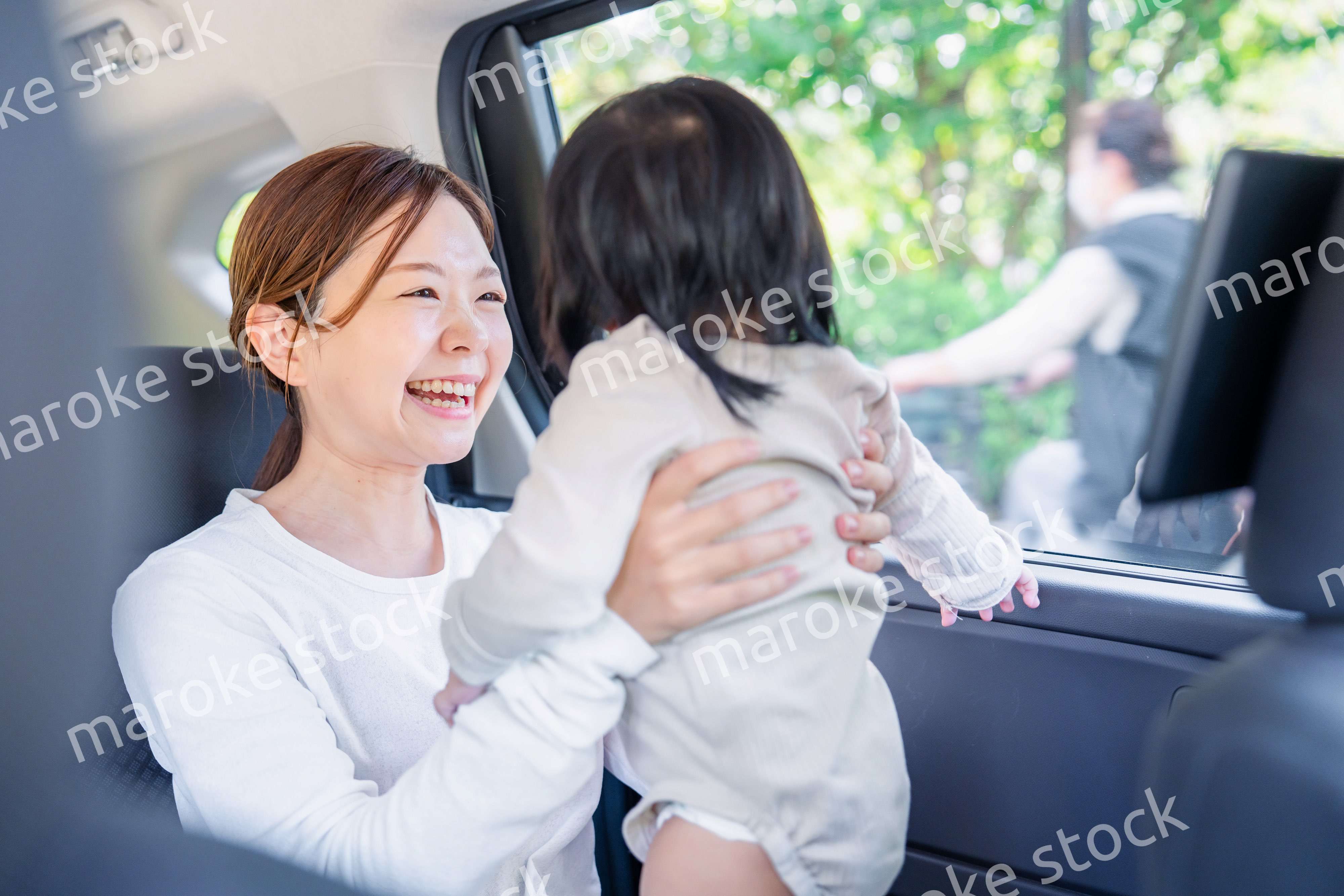 小さい子供と一緒にタクシーに乗るお母さん