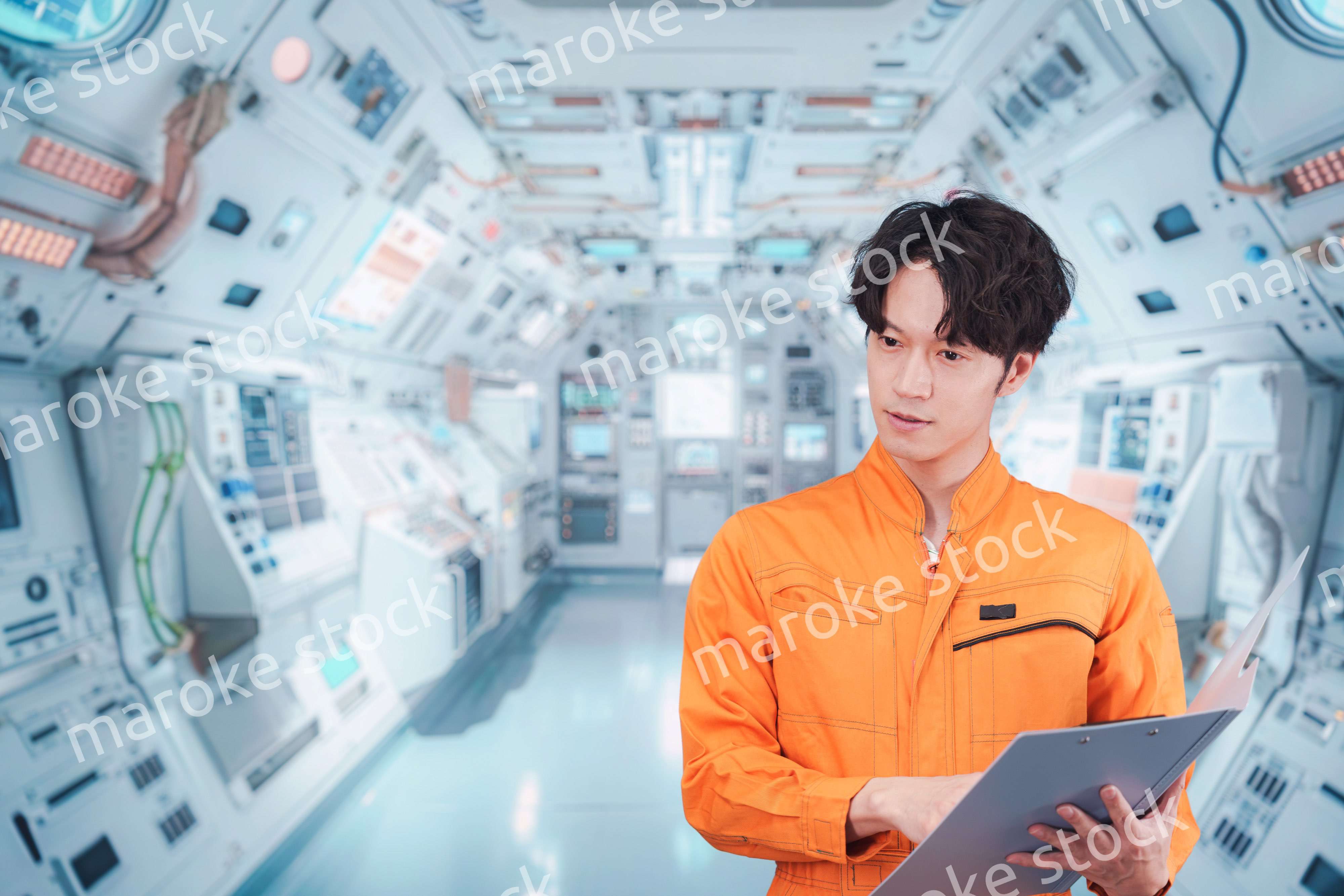 宇宙ステーションの中で働く若い男性の宇宙飛行士